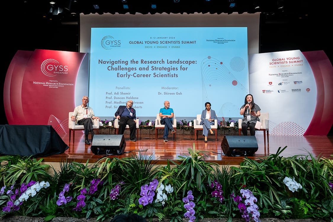 Five panelists seated on stage at the 2024 Global Young Scientists Summit in Singapore, with floral decor in front.