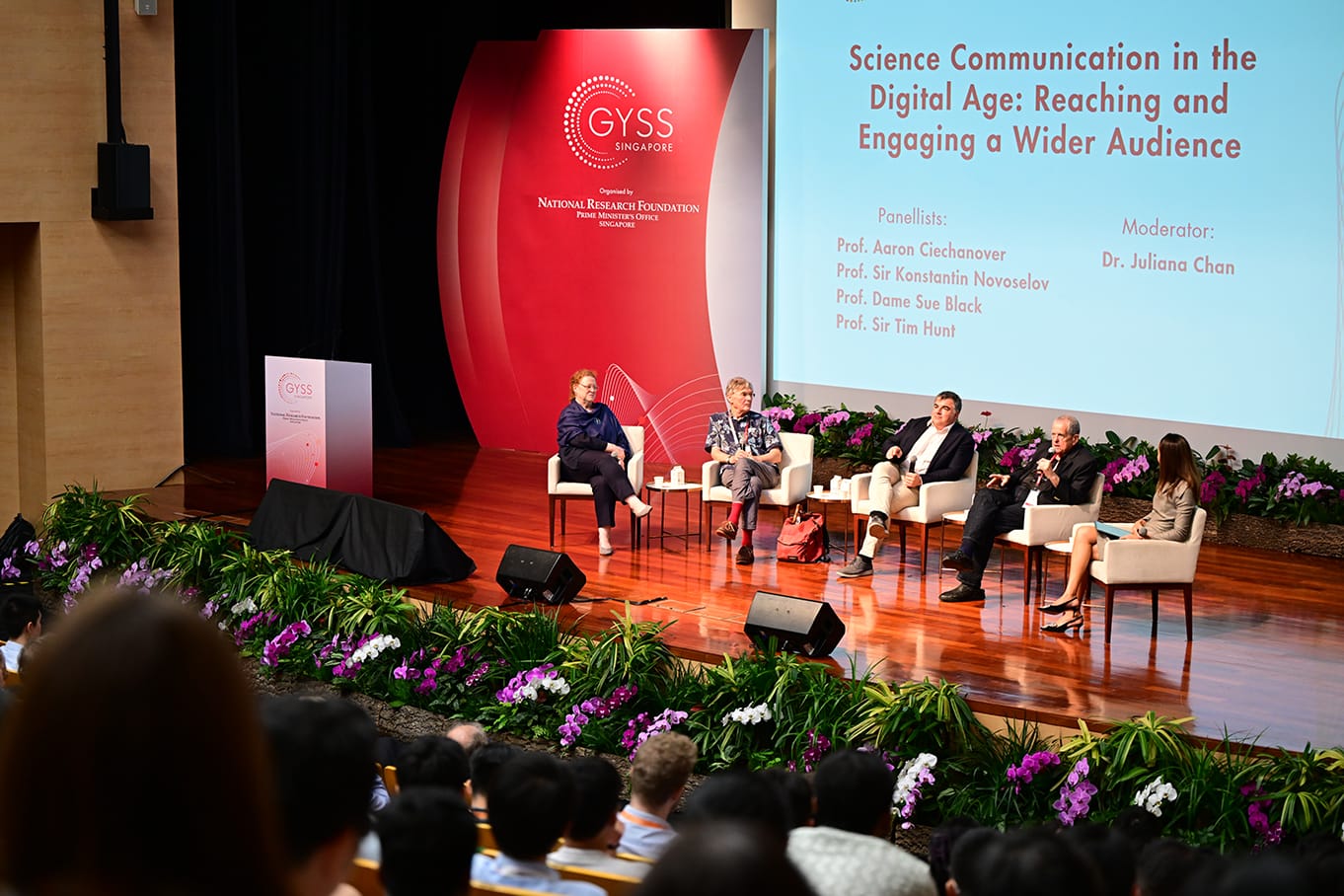 Five panelists seated on a flower-decorated stage at GYSS Singapore discuss Science Communication in the Digital Age.