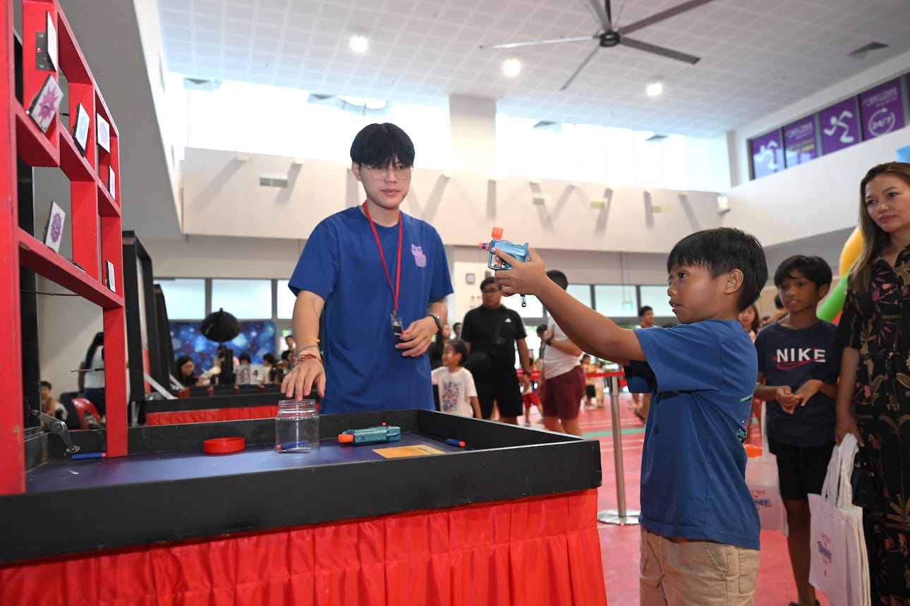 Boy playing carnival shooting game.