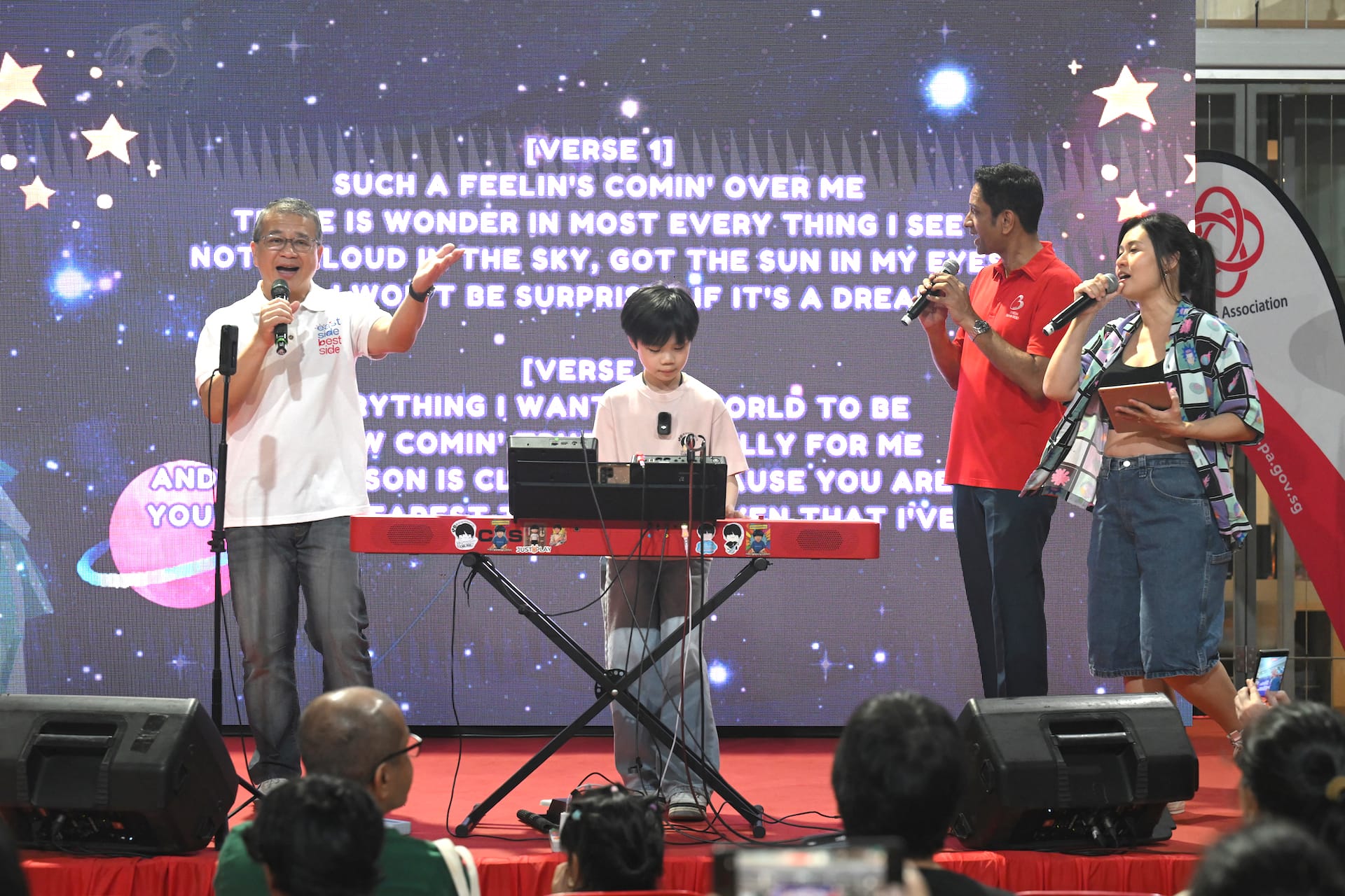 Min Edwin and MOS Dinesh singing along on stage.