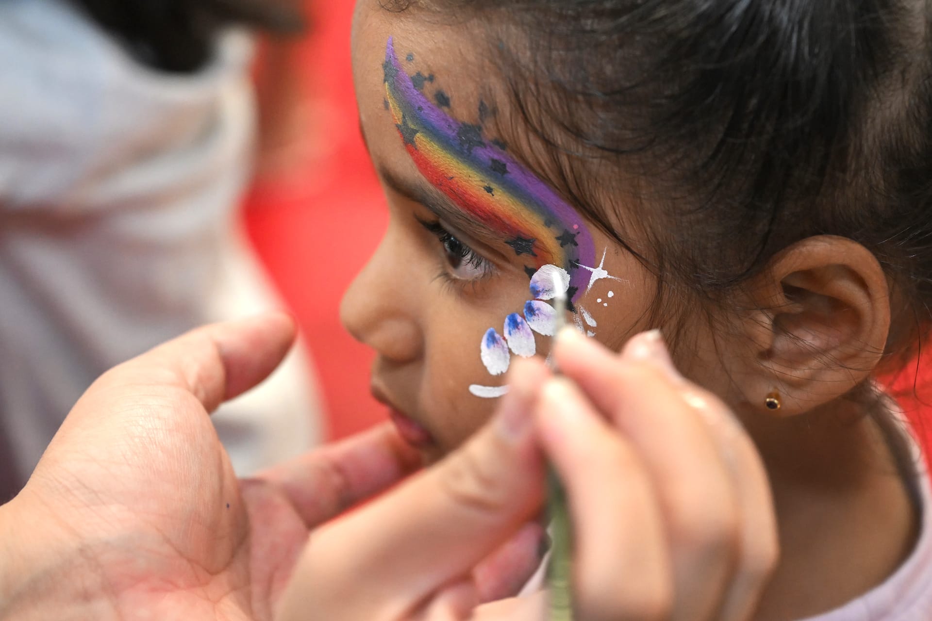 Girl having her face painted for the celebration.