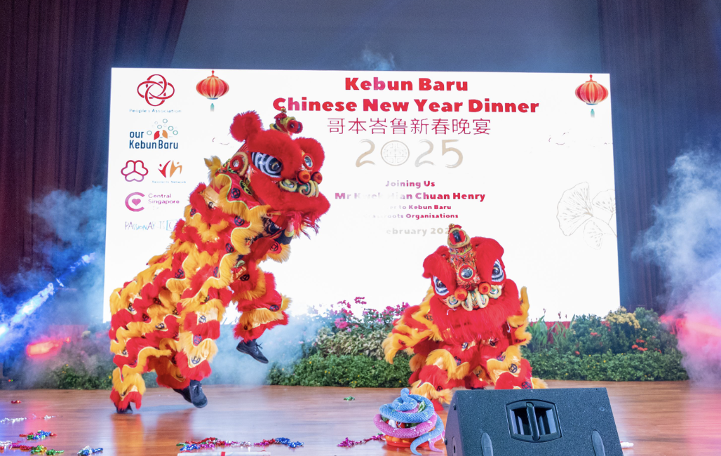 Two red and yellow lion dance performers on stage at Kebun Baru Chinese New Year Dinner 2025.