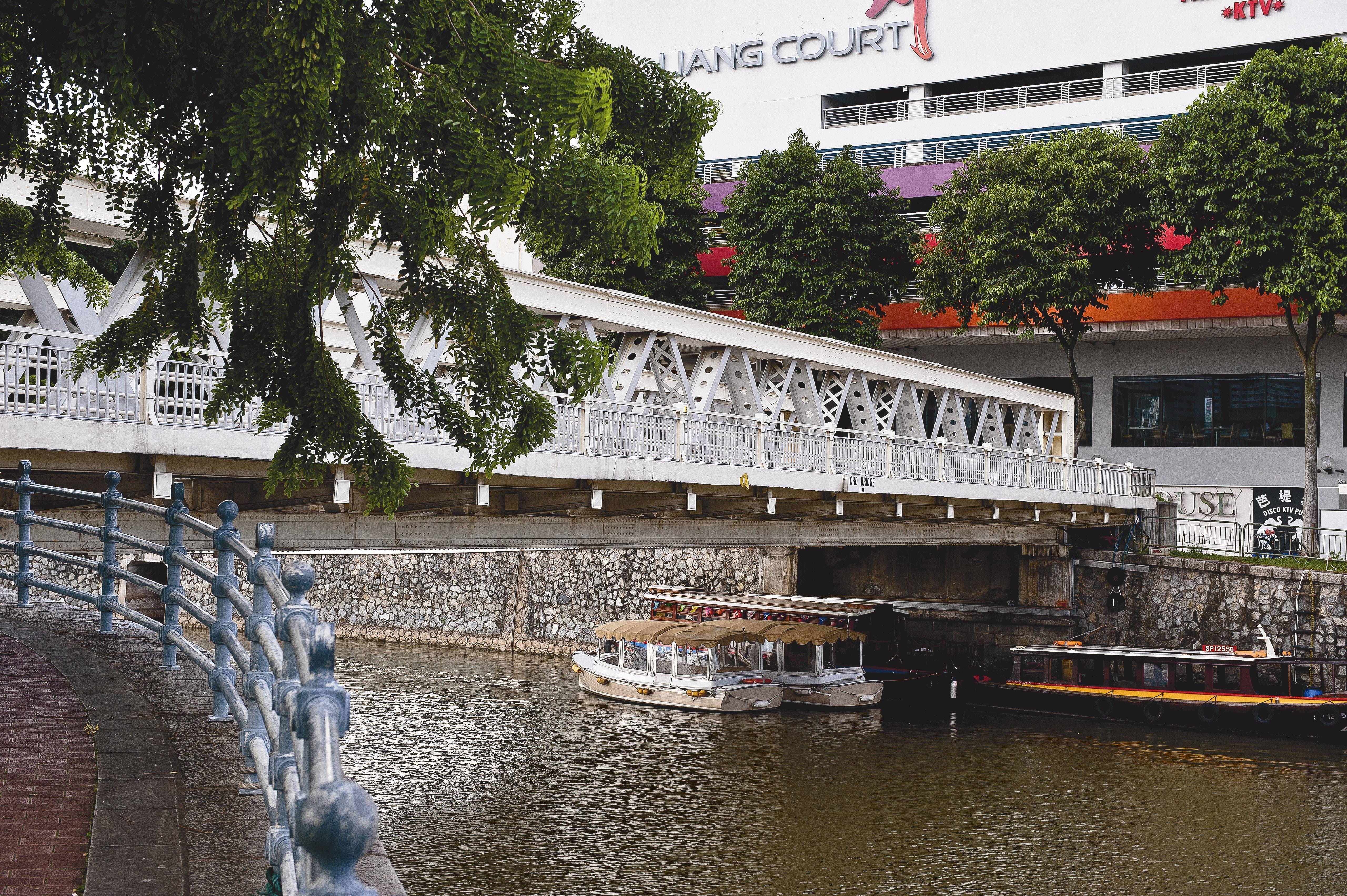 Ord Bridge spanning the Singapore River, with riverboats passing beneath