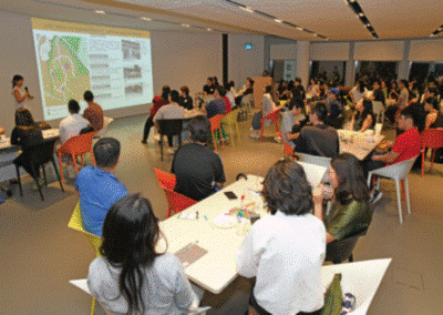 Audience at an indoor community engagement session with projected map
