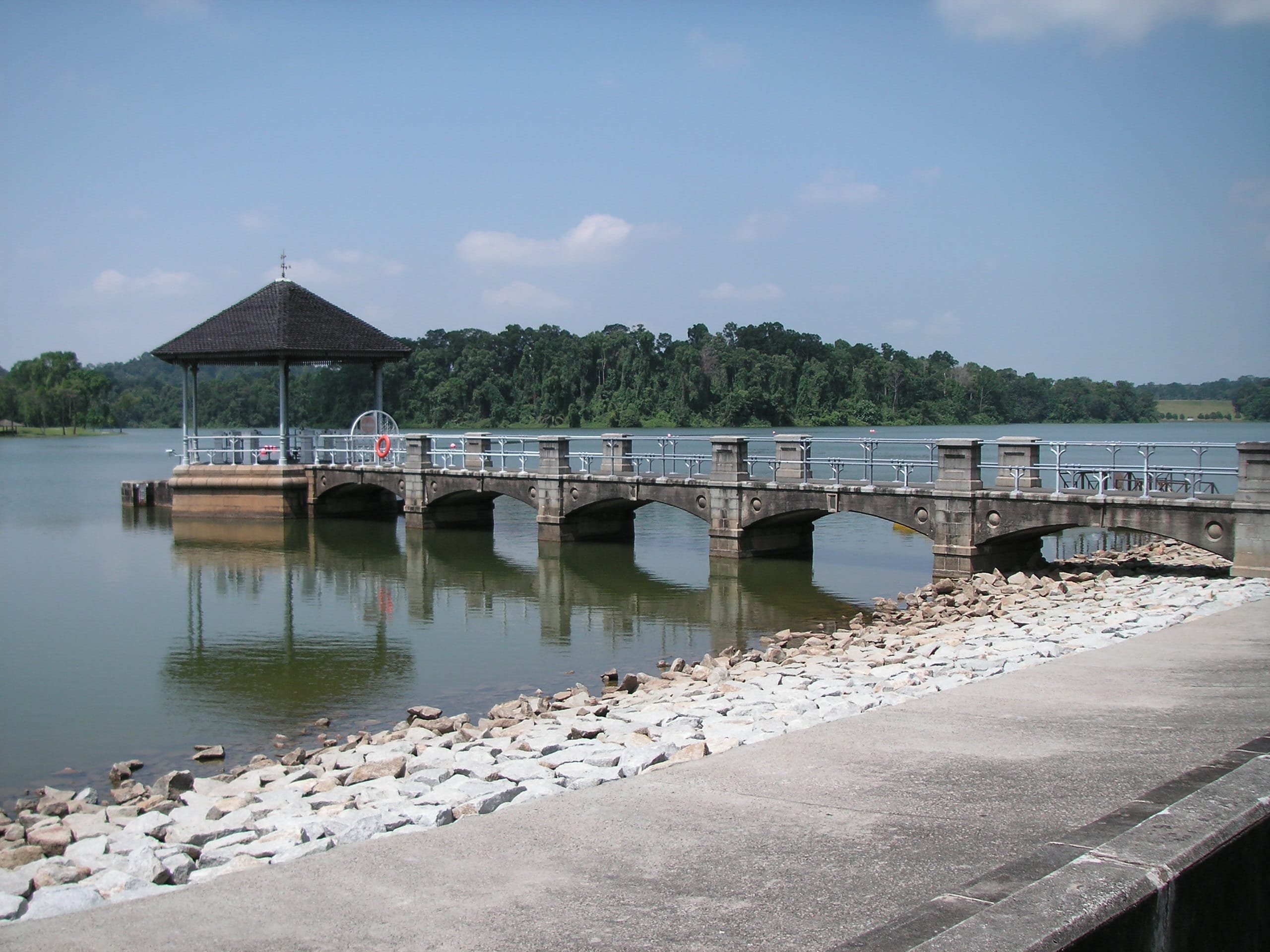 Pavilion connected by a stone bridge extending into Lower Peirce Reservoir