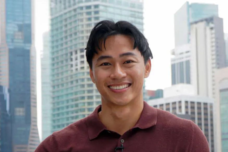 Toufiq Andry Guruh, URA Scholar, smiling with the Singapore city skyline in the background