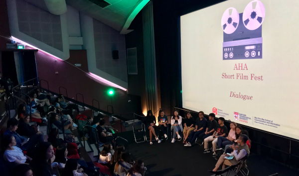Audience watching "AHA Short Film Fest: Dialogue" panel discussion in a cinema.