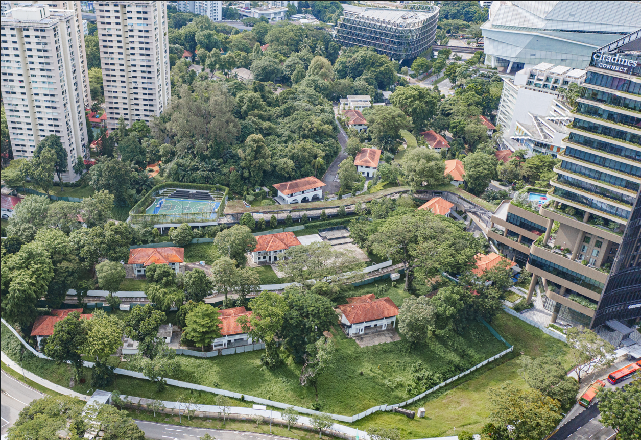 Aerial view of a residential area with houses amidst trees, bordered by skyscrapers in Singapore.