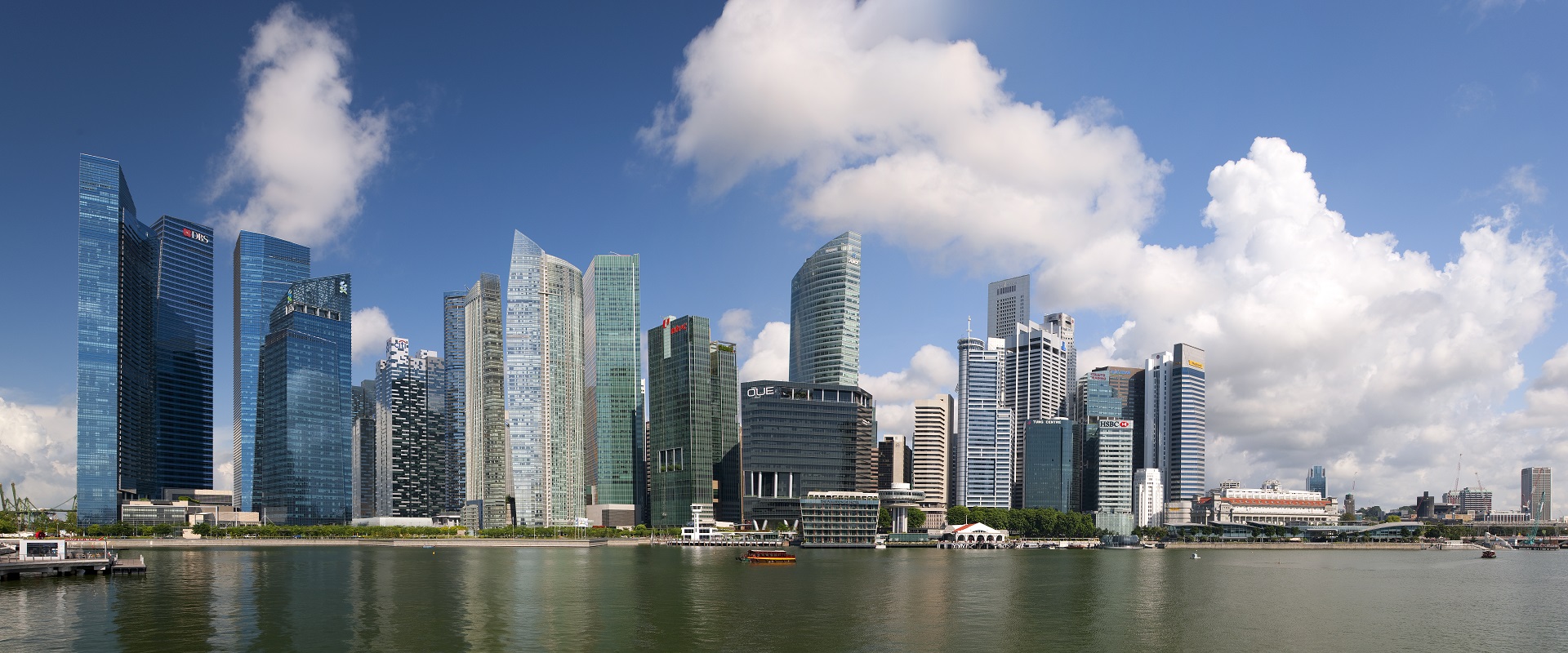 Panoramic view of the Singapore CBD with modern skyscrapers by the waterfront.