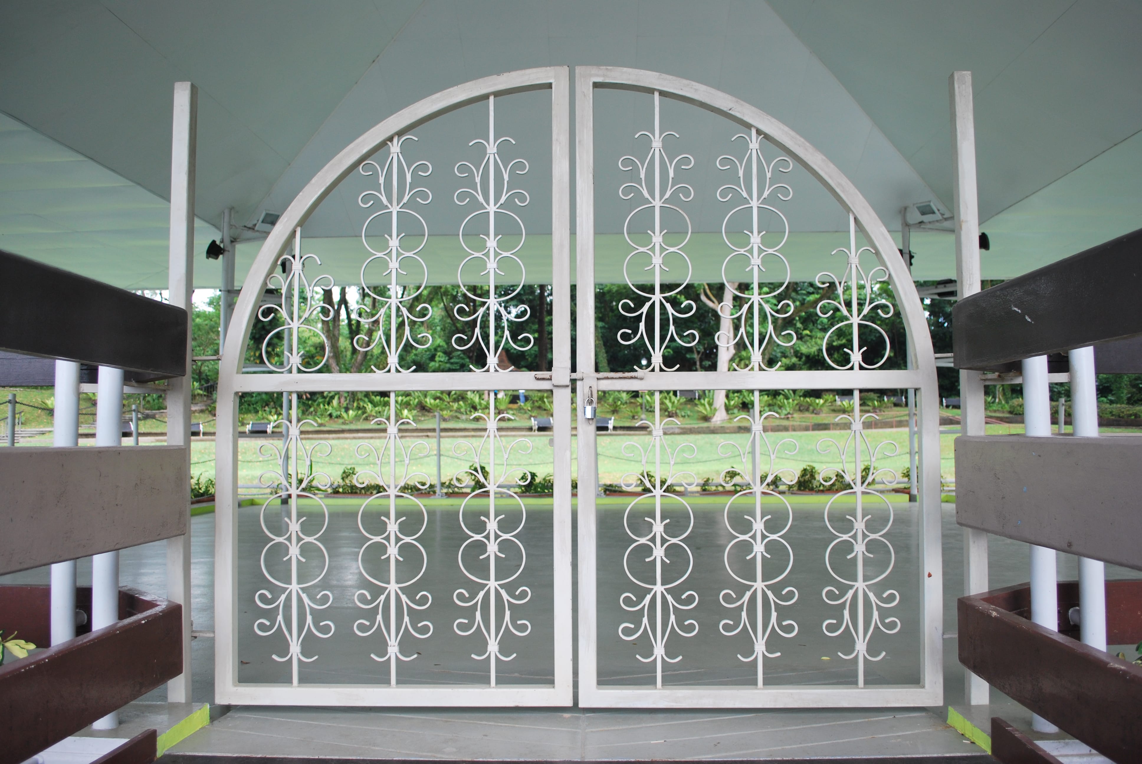 Decorative white metal gate at the entrance to the MacRitchie Reservoir bandstand