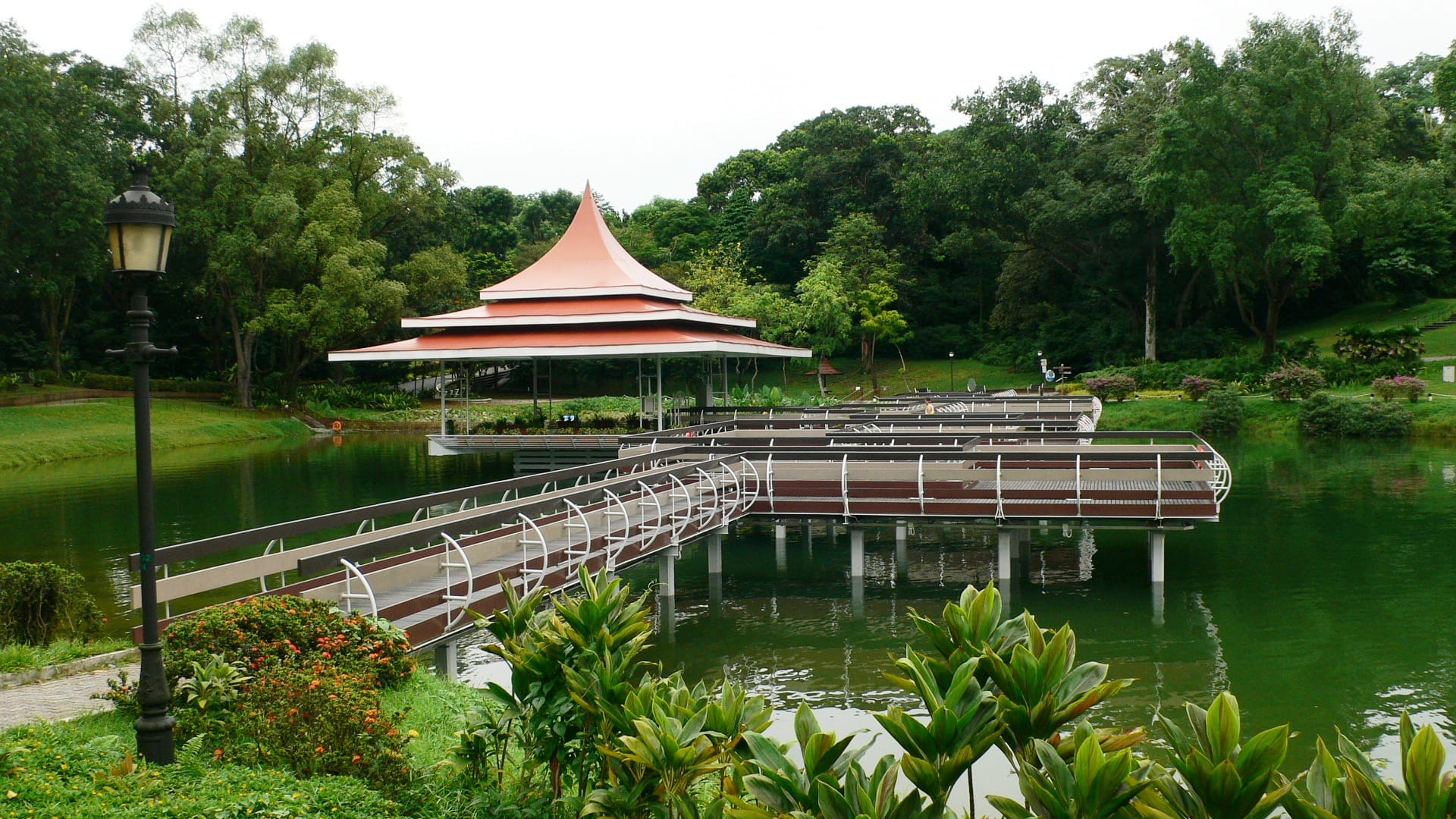 Zig-zag bridge leading to the floating bandstand surrounded by greenery