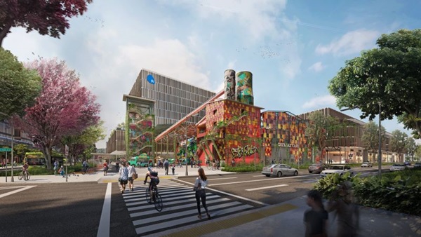Street view of a multi-building complex with shops, offices, and a colorful central structure with graffiti and towers.