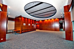 Modern interior with wood paneling, gray carpet, and a circular ceiling light.