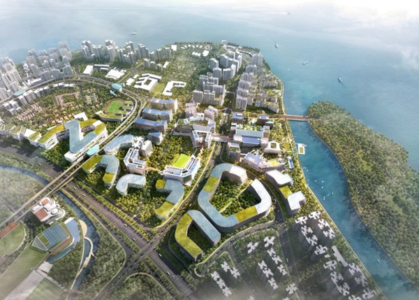 Aerial view of a coastal city with modern buildings, green spaces, and a bridge connecting to an island.