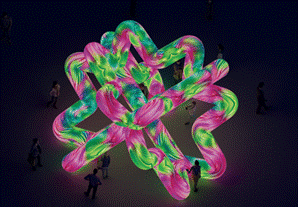 Large neon pink and green inflatable knot sculpture with crowd below