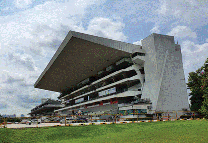 Modern grandstand building with cantilevered roof under blue sky