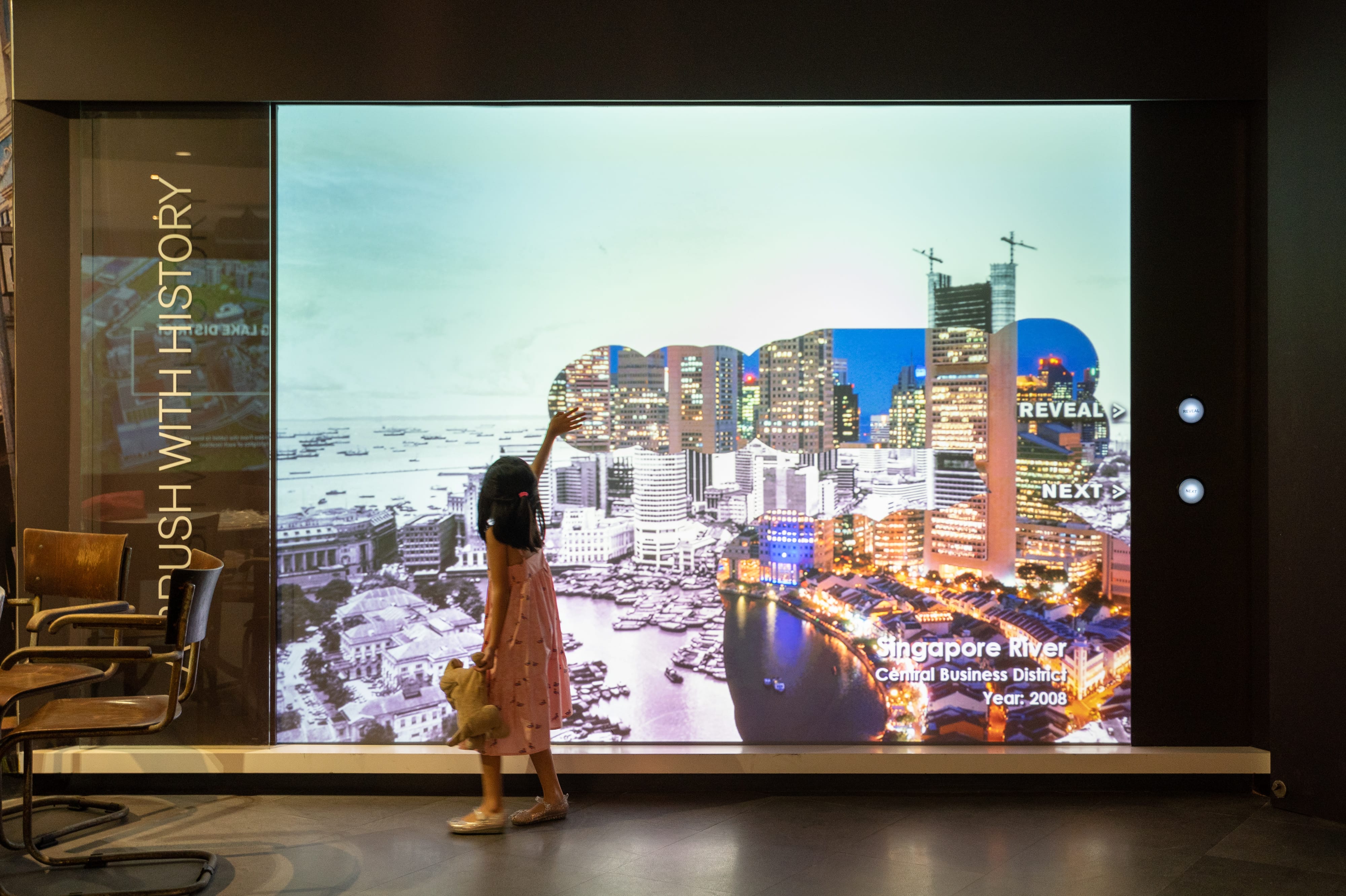 A girl brushing her hand on an exhibit.