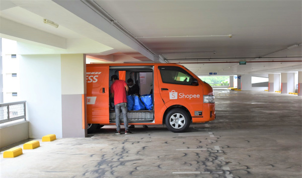 A Shopee delivery van is loaded with packages in a parking garage.