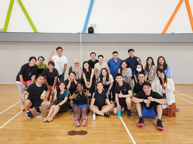 People in athletic wear on an indoor sports court.
