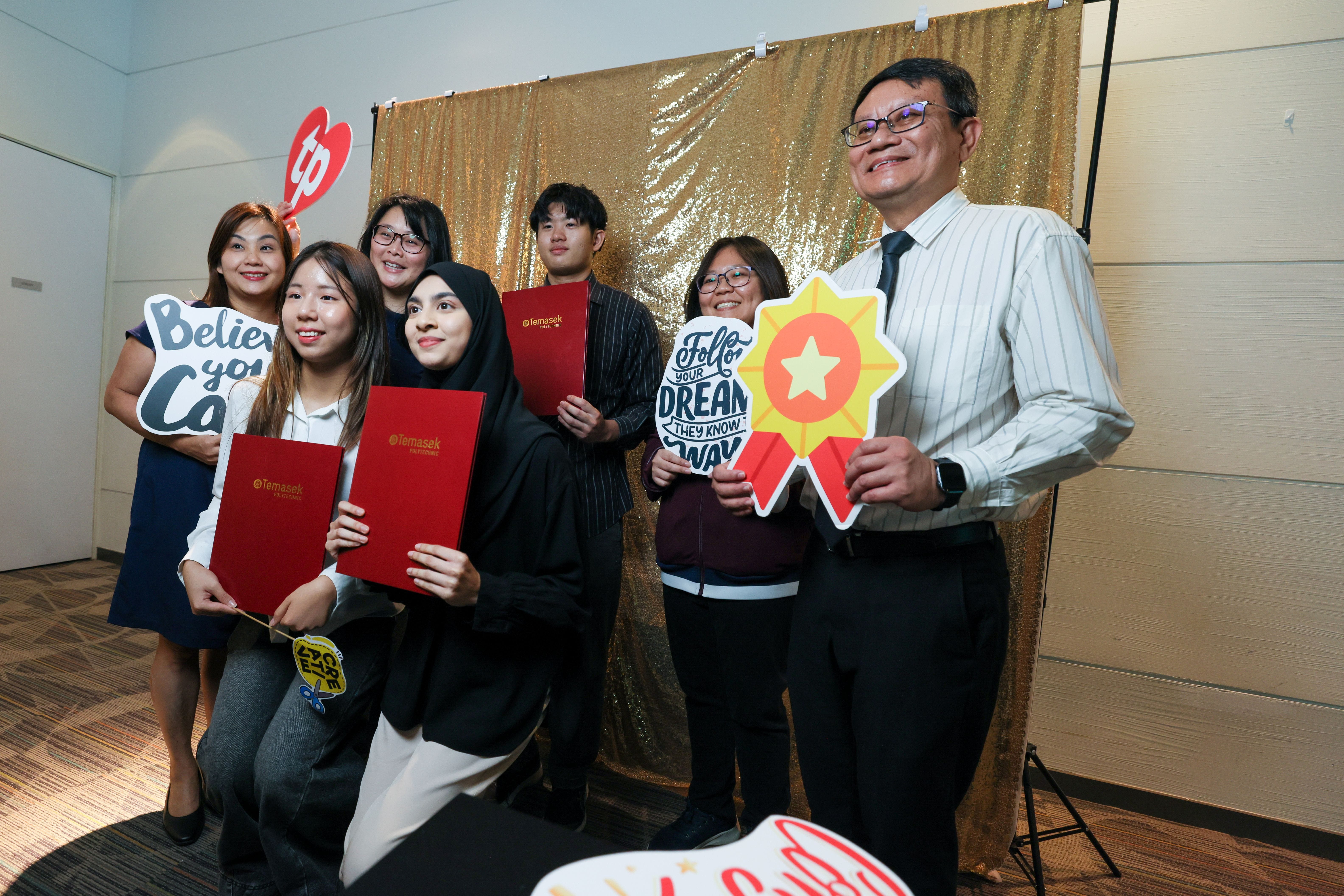 Image of students and staff take a photo at the photo booth the TP Scholarships Presentation