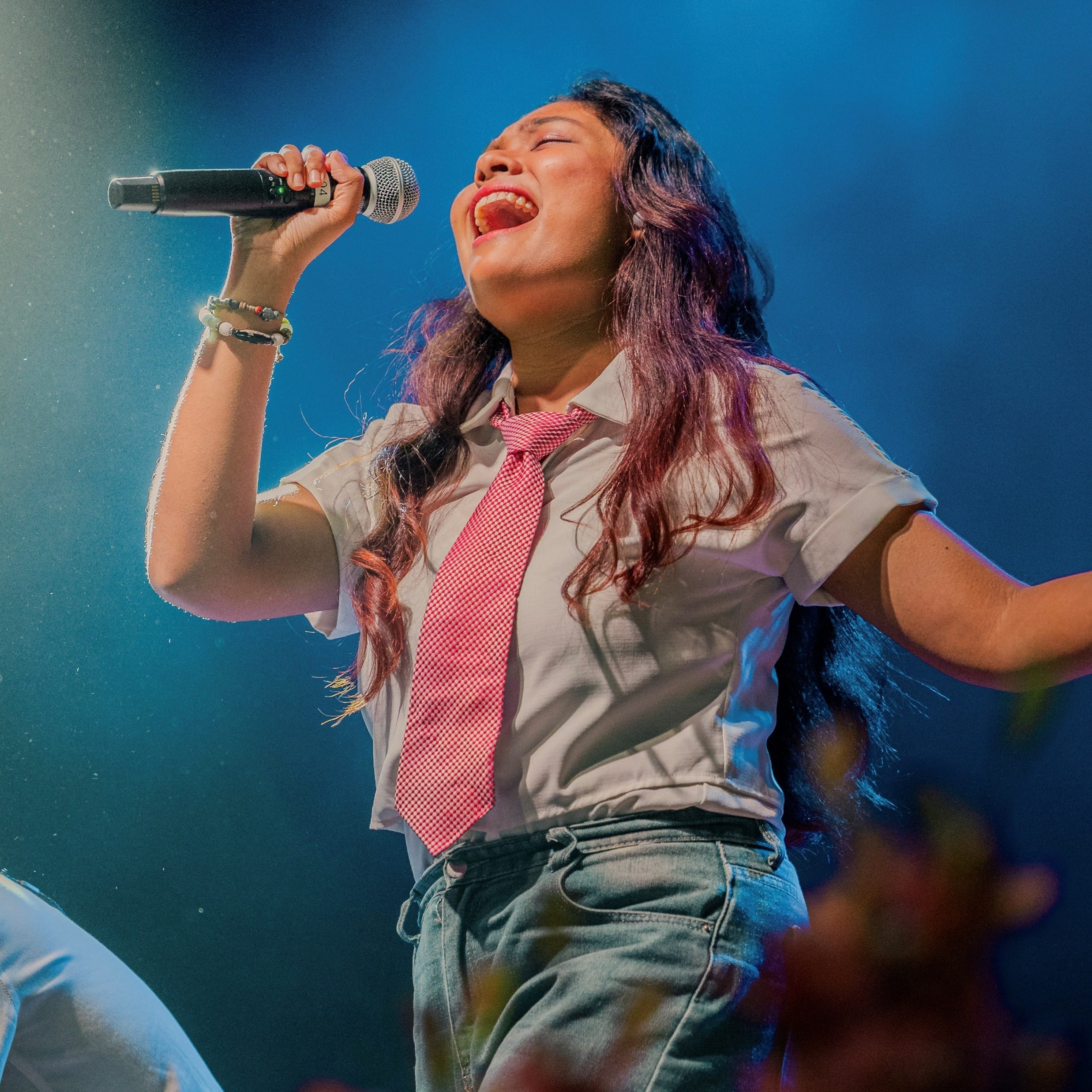 Image of a Music Vox CCA student singing at a campus concert in TP