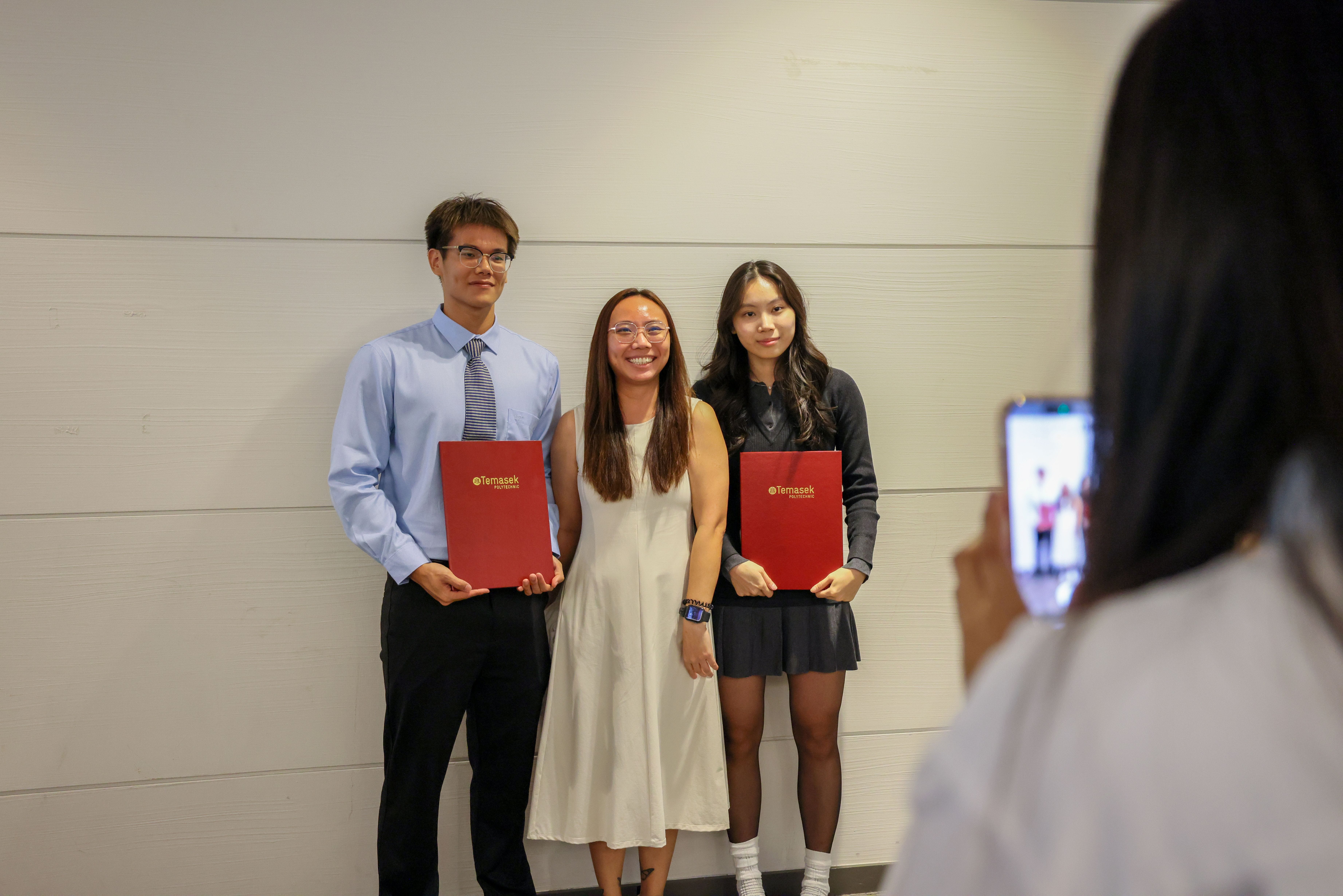 Image of students and staff take a photo outside the auditorium at the TP Scholarships Presentation