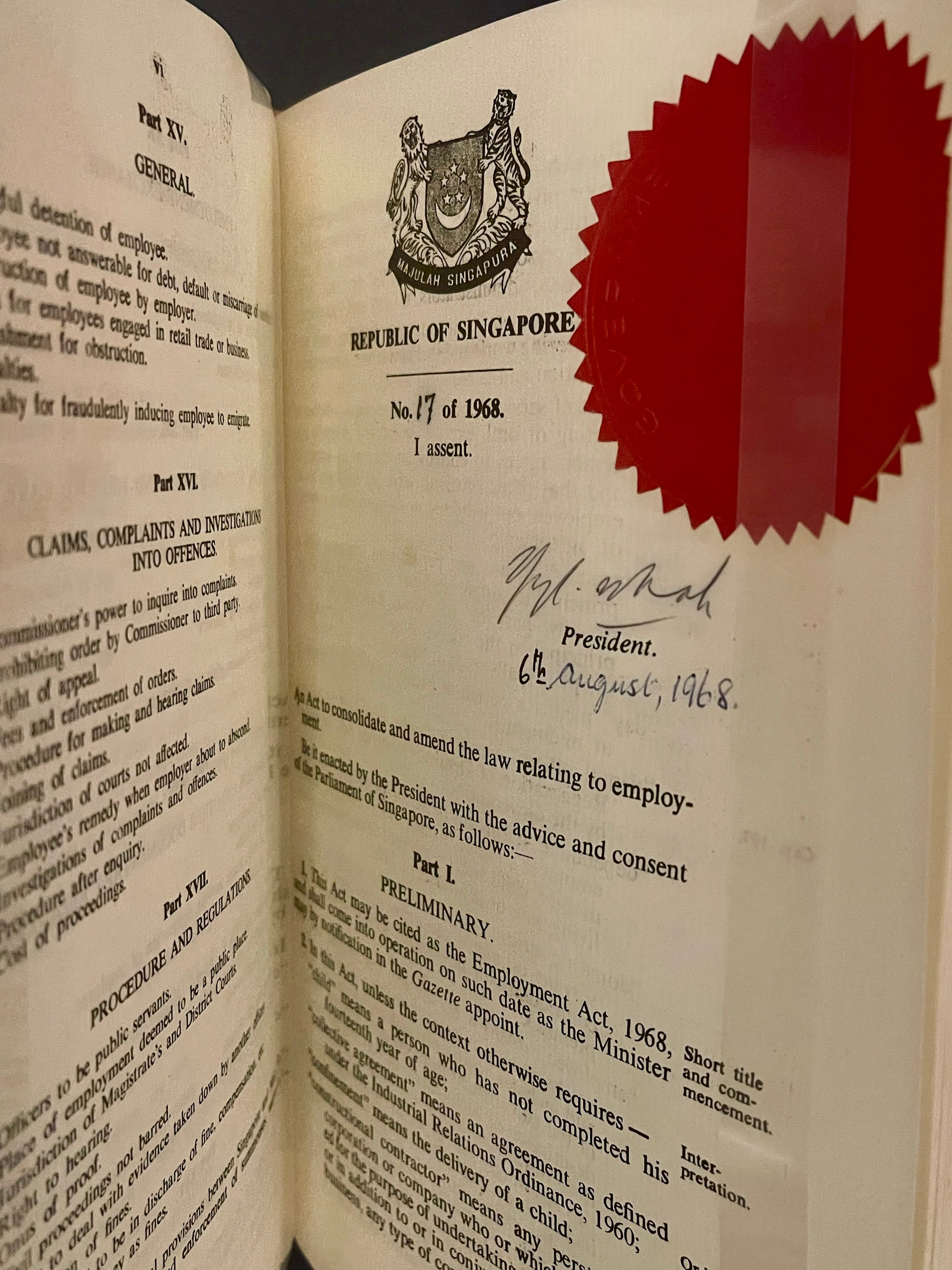 An open book showing the Republic of Singapore Employment Act No. 17 of 1968, signed by the President on 6th August 1968, with a red seal.
