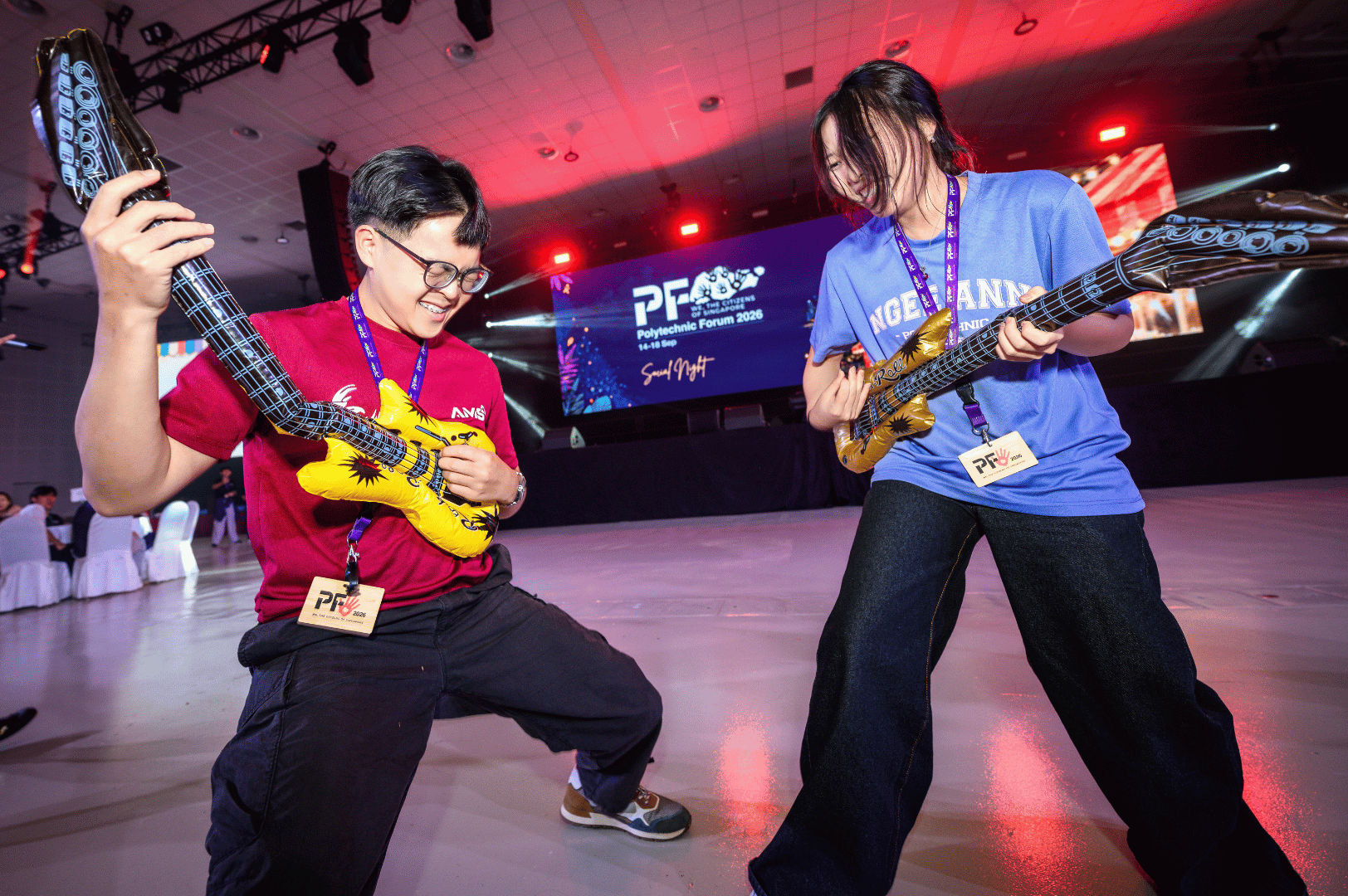2 students playing a fake guitar during social night