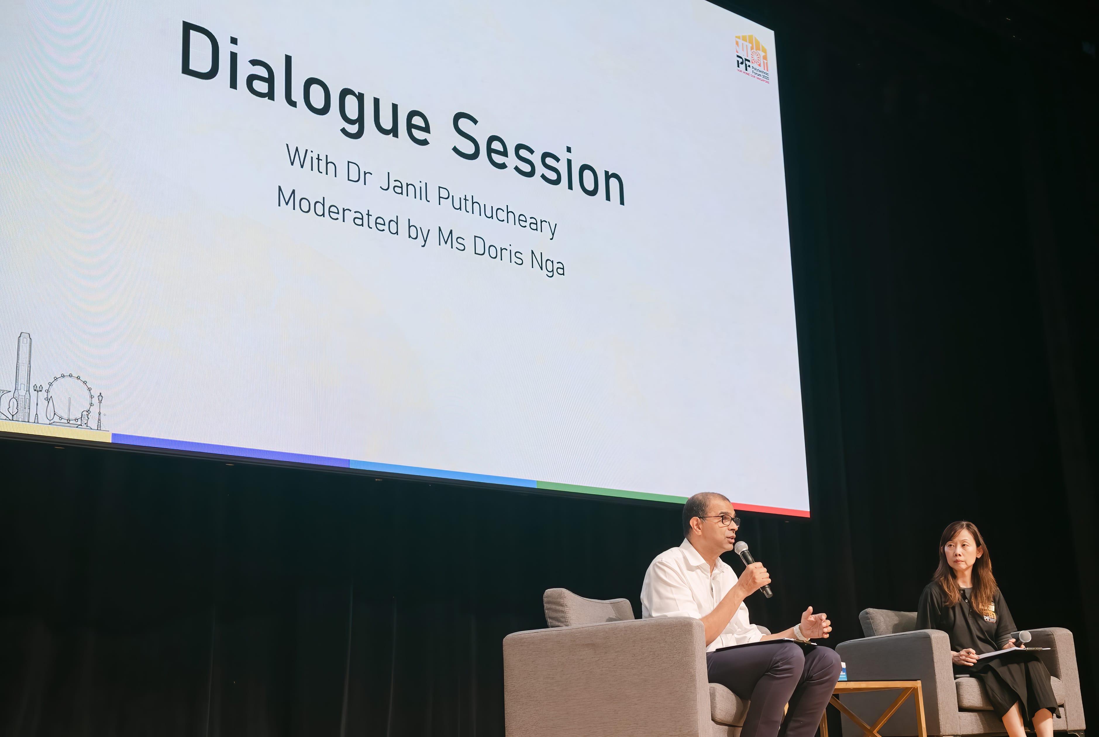 Two people sit on stage chairs during a Dialogue Session with Dr Janil Puthucheary, moderated by Ms Doris Nga.