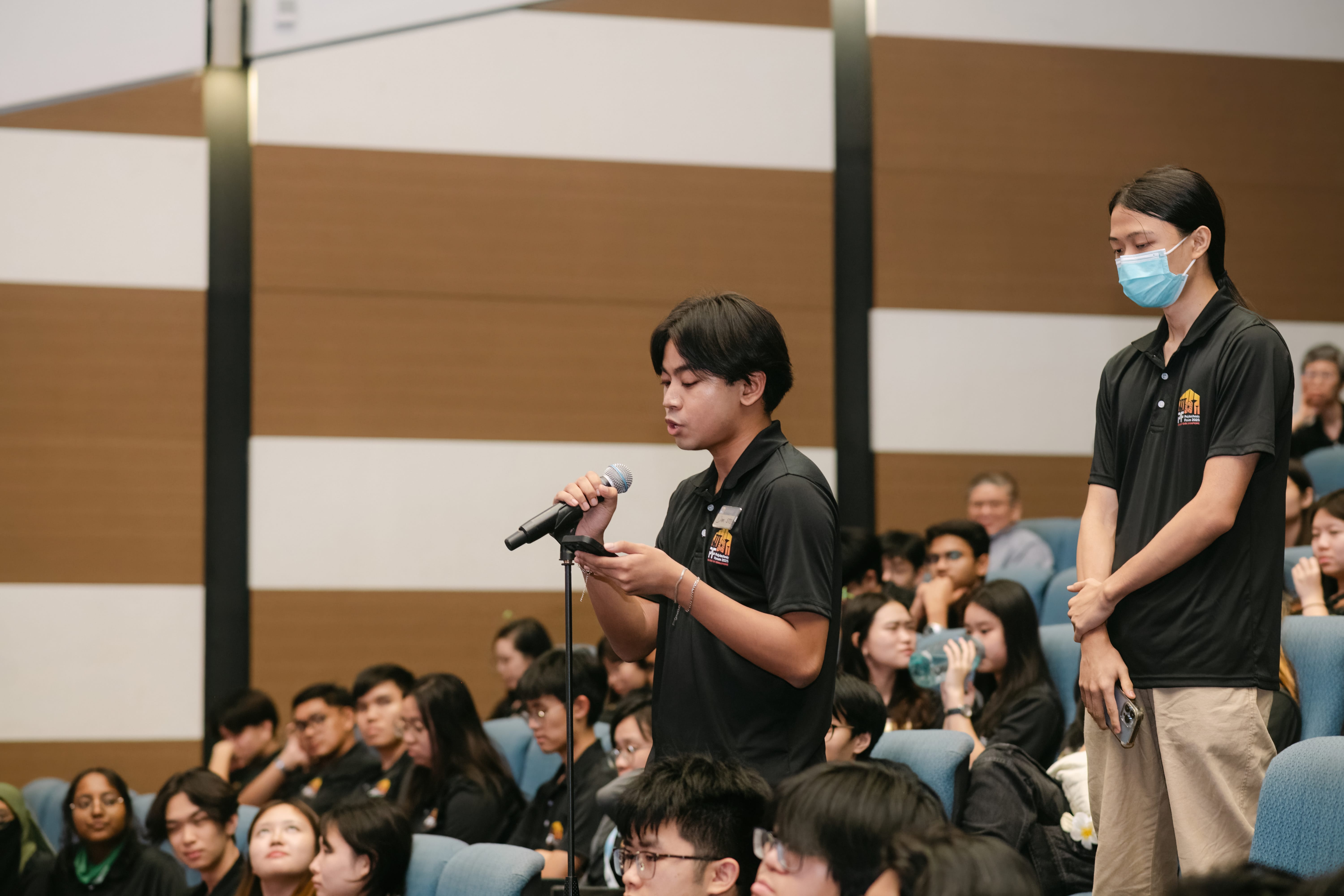 A student in black speaking into microphone