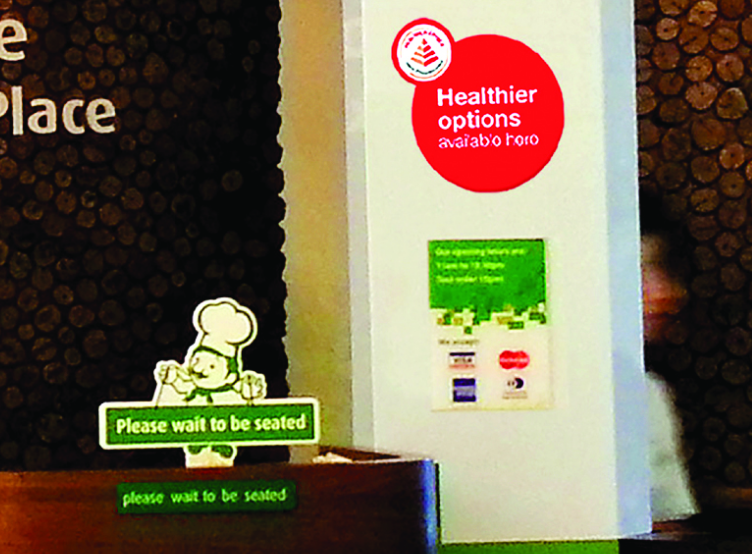 Restaurant entrance displaying sign that healthier options are available here.