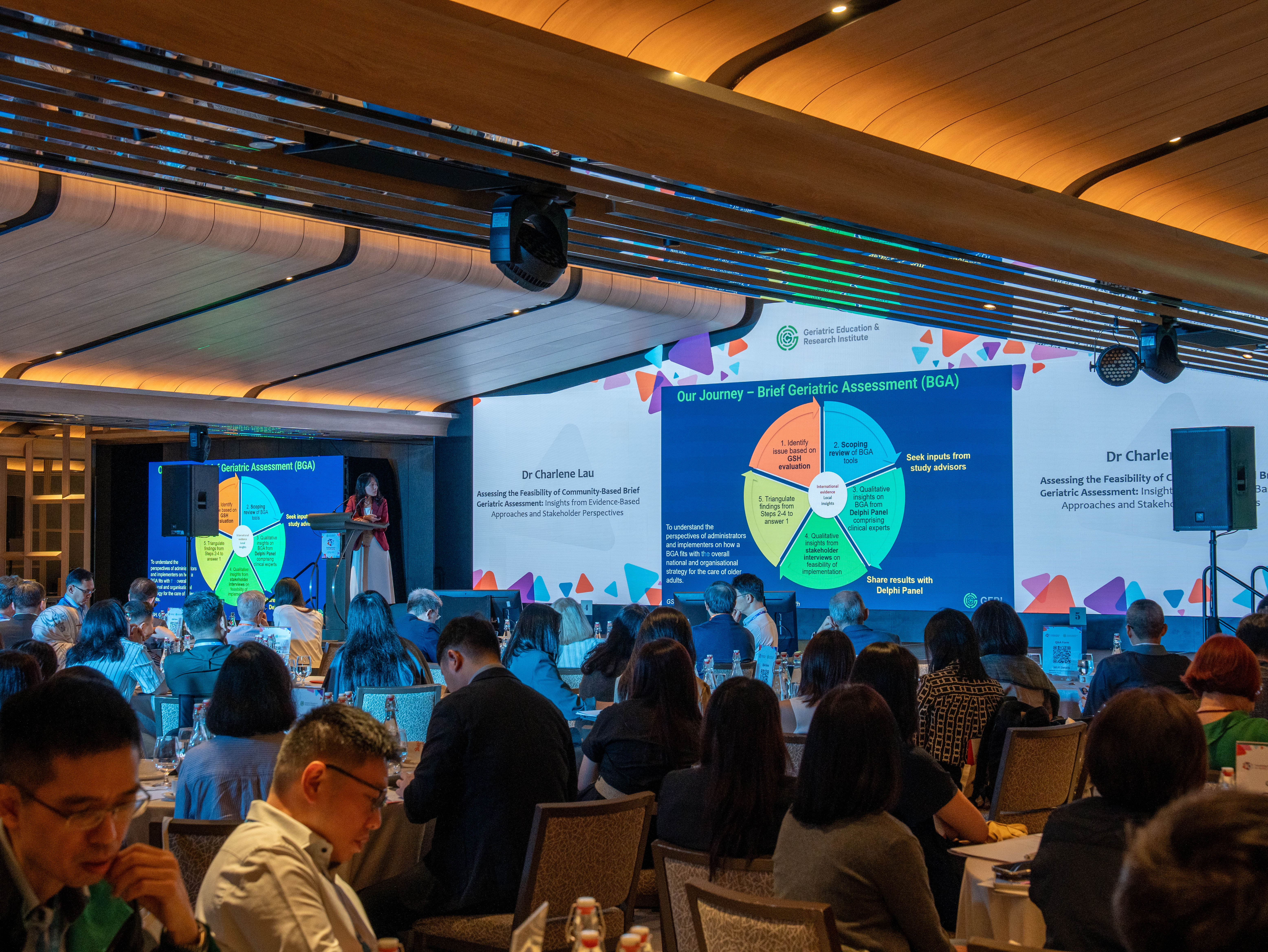 Guests watching plenary presentation on stage