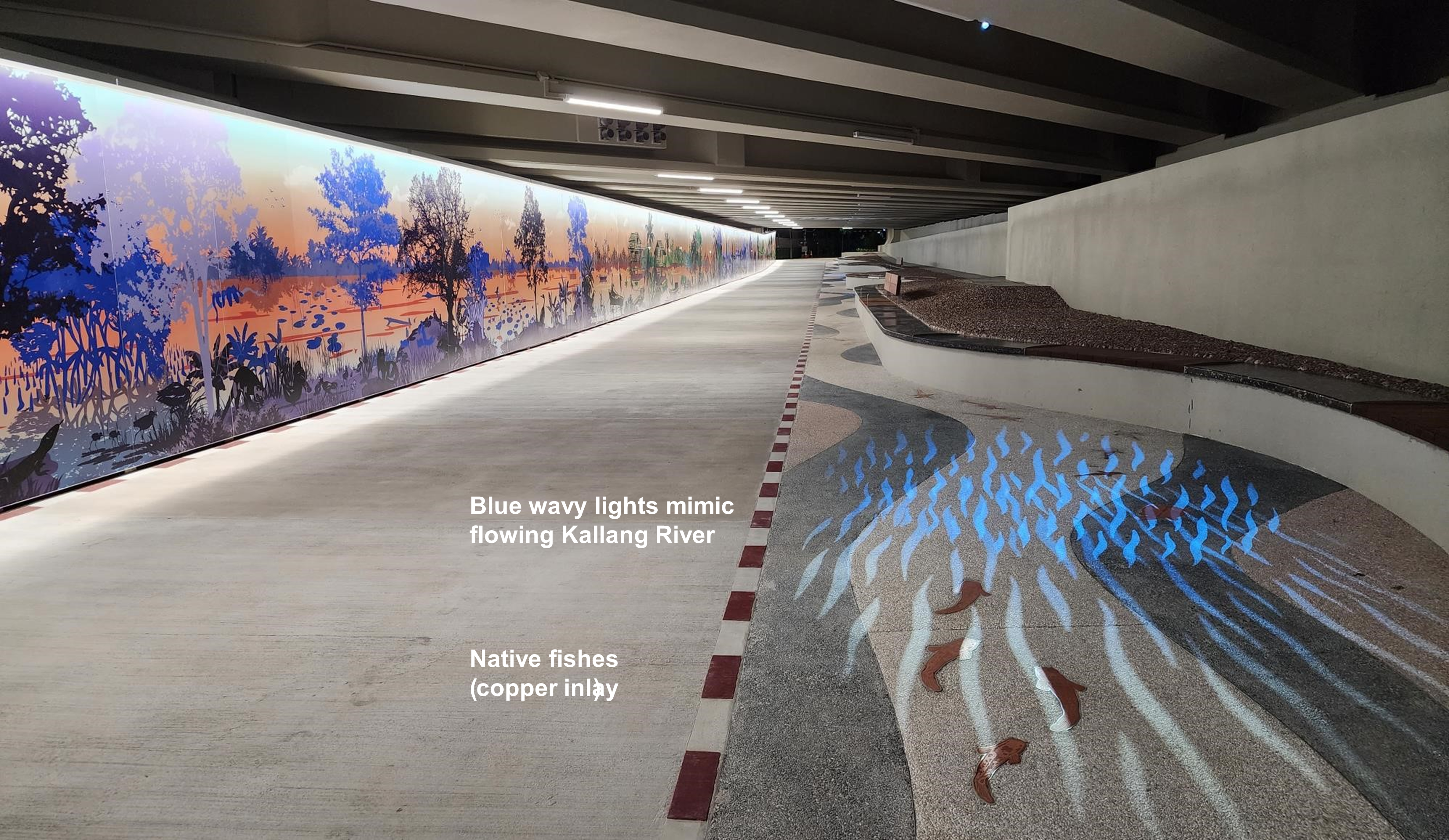 Underpass with mural of wetlands, blue light river on floor, and inlaid copper fish.