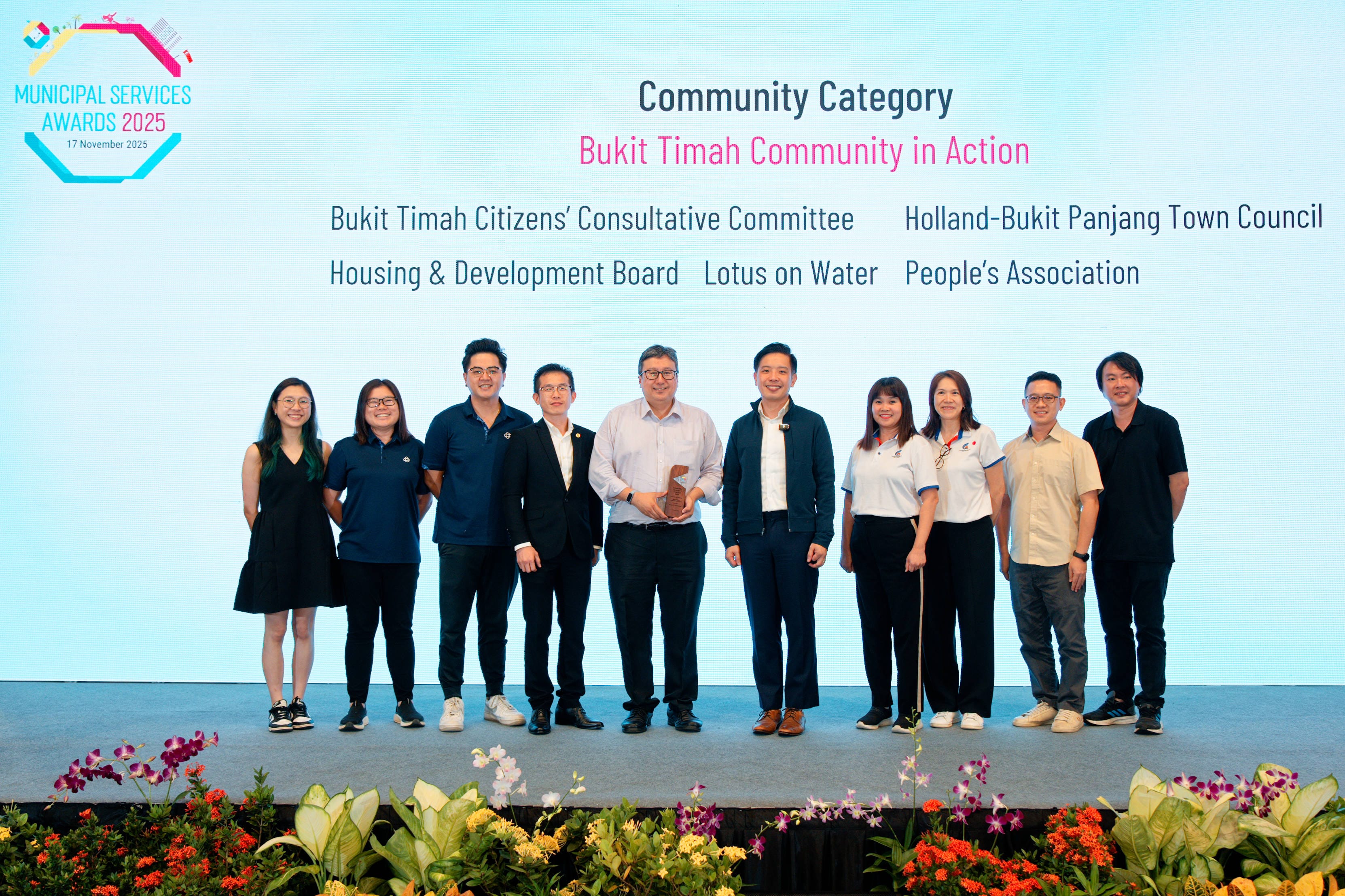 Group of people onstage in front of screen for Municipal Services Awards 2025 ceremony.