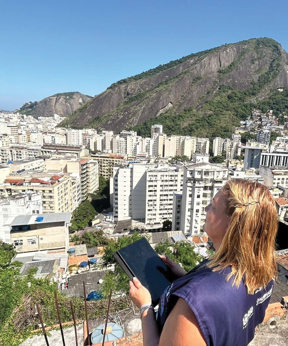 Lady holding Ipad while viewing the buildings at Copacabana Beach in Rio de Janeiro