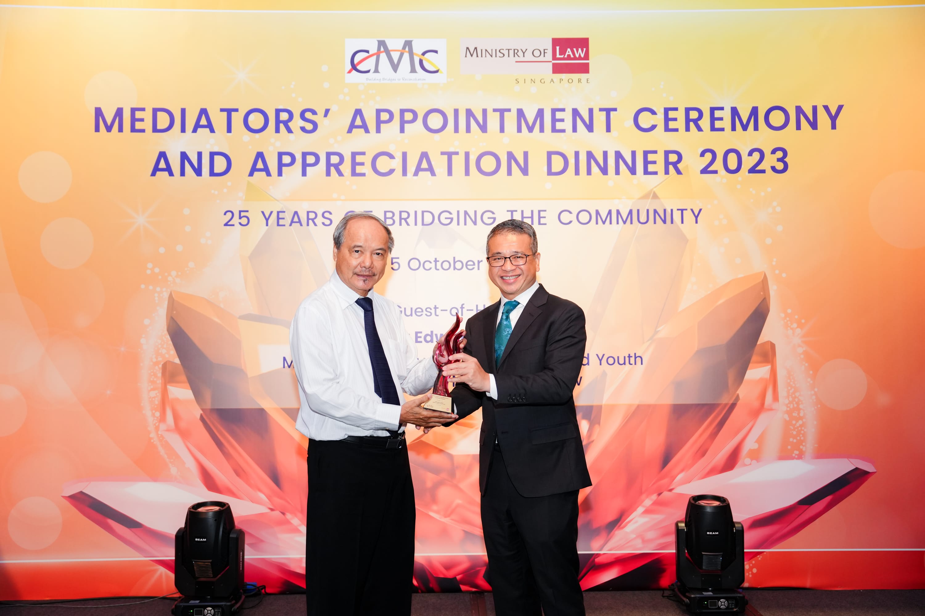 Two men in formal attire hold a trophy together at the CMC Mediators Appointment Ceremony and Appreciation Dinner 2023.