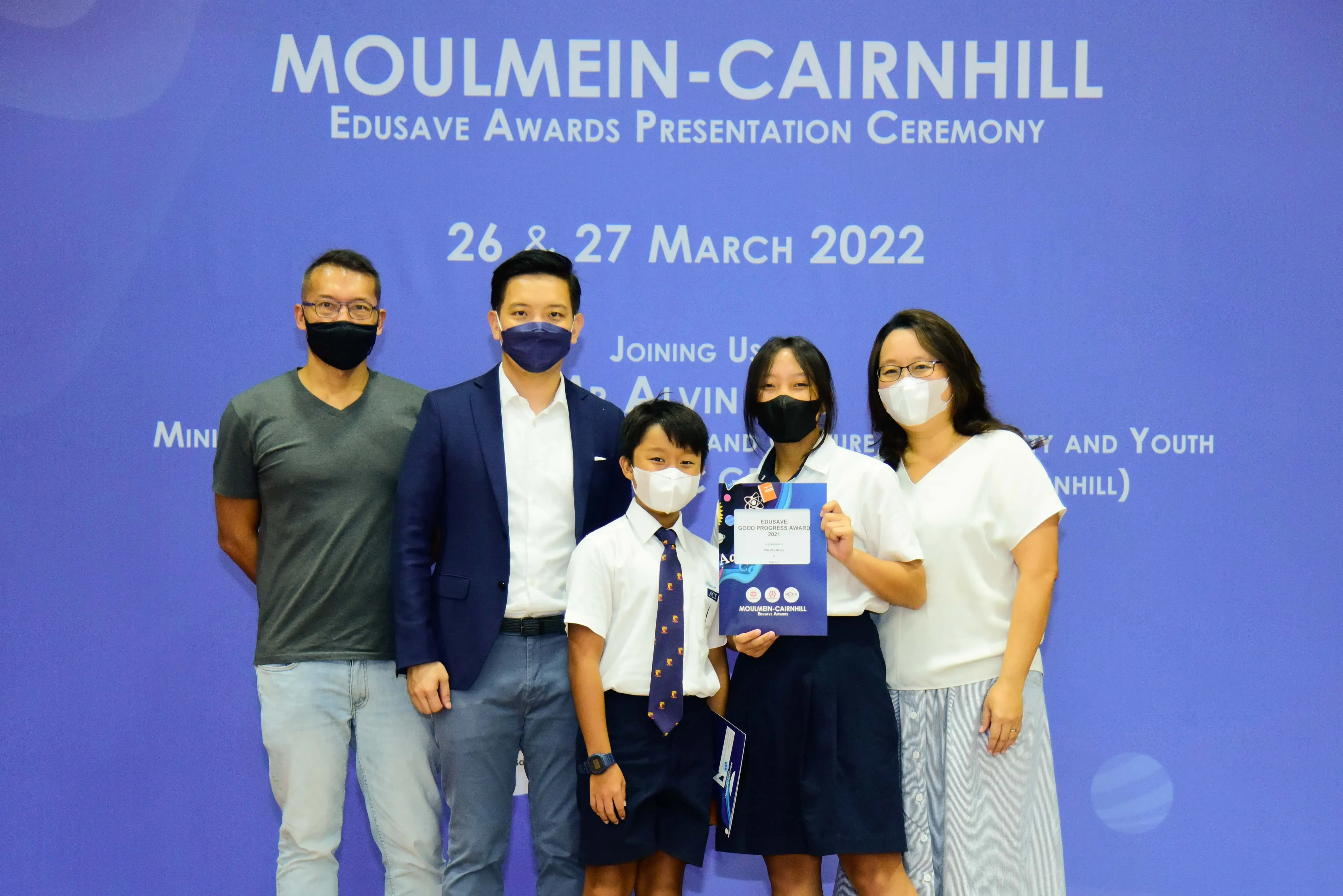 Five masked people pose at the Moulmein-Cairnhill Edusave Awards Presentation Ceremony on 26-27 March 2022.