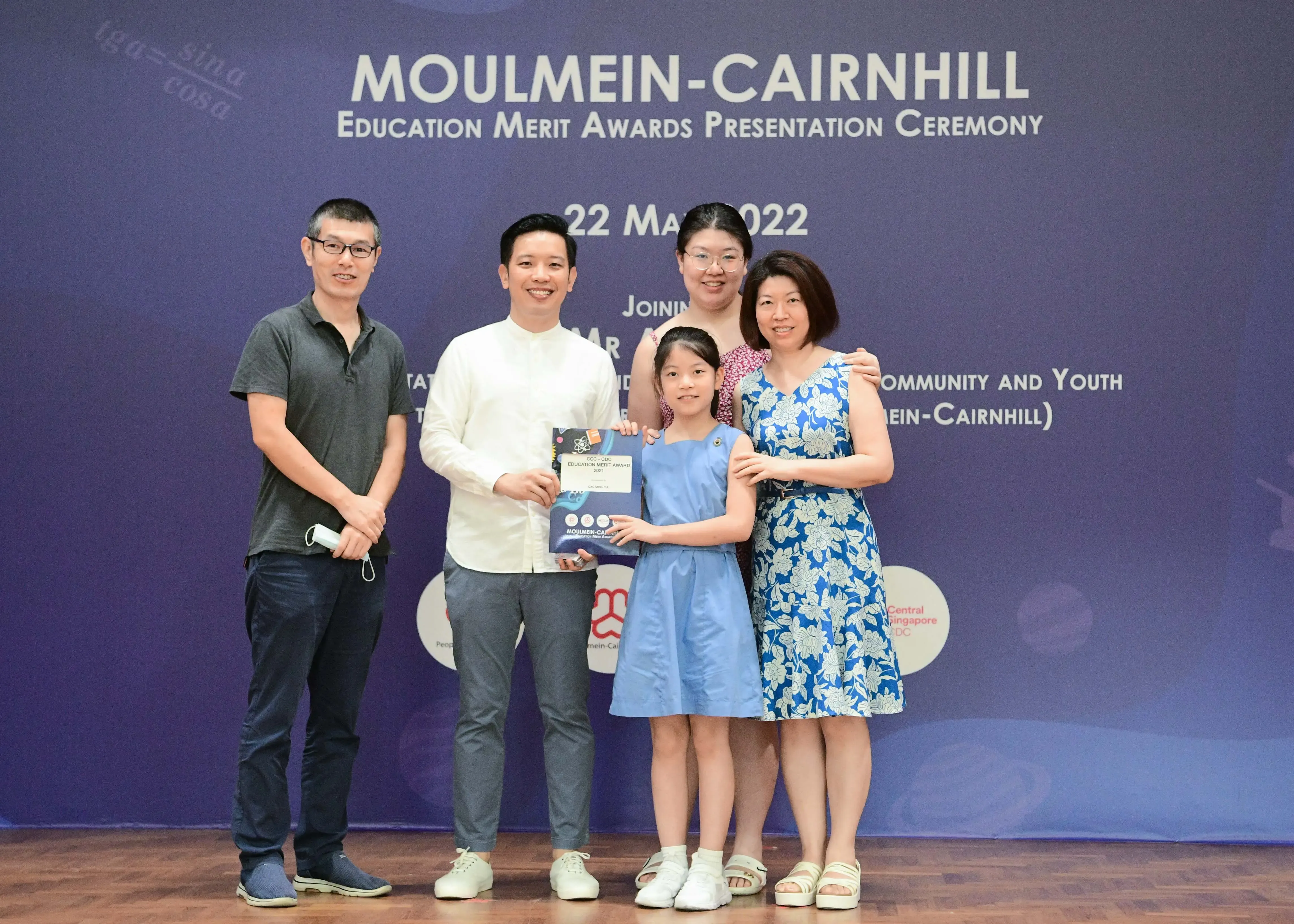 Five people pose with an award certificate at the Moulmein-Cairnhill Education Merit Awards Ceremony on 22 May 2022.