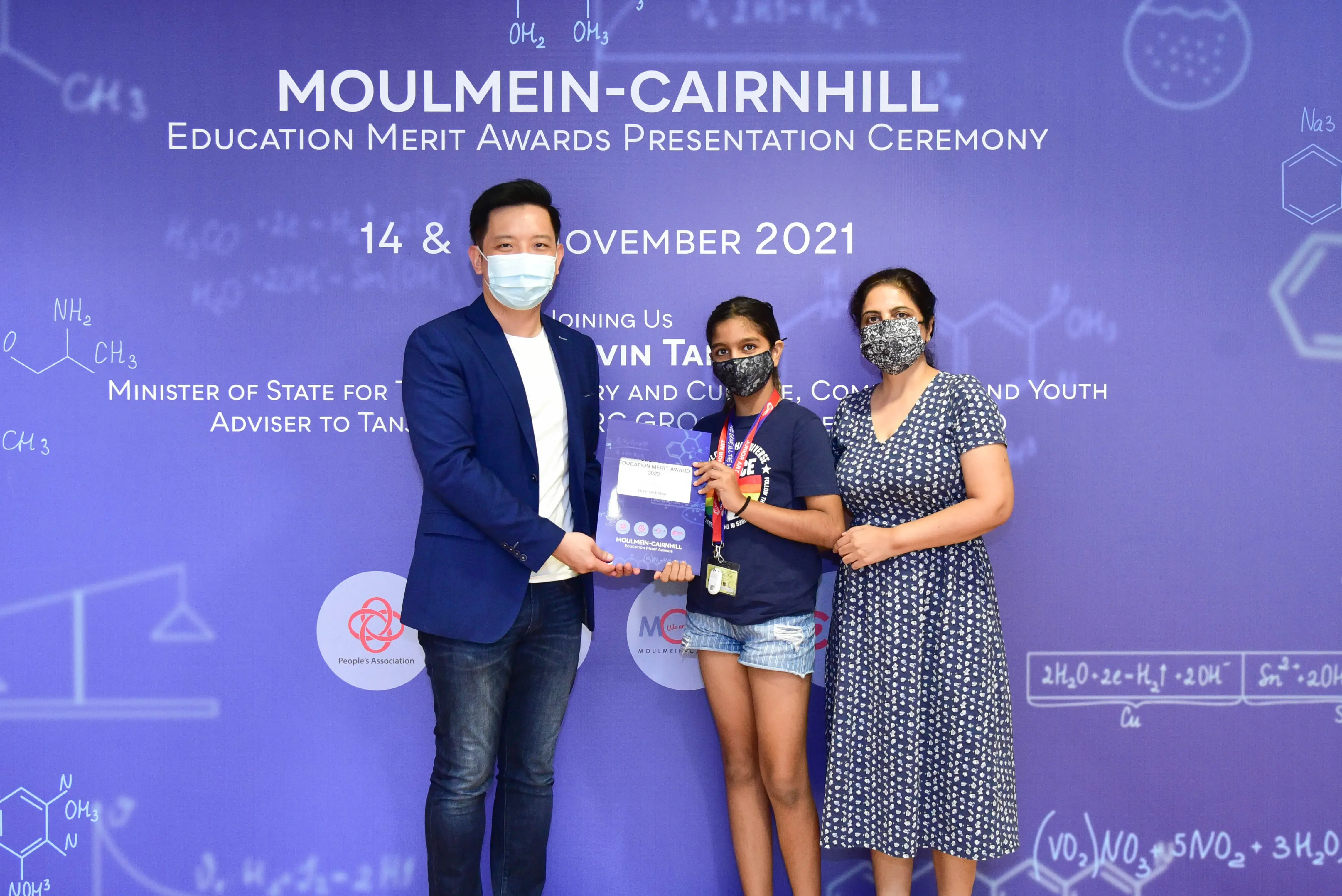 Three masked people pose at the Moulmein-Cairnhill Education Merit Awards Presentation Ceremony, November 2021.