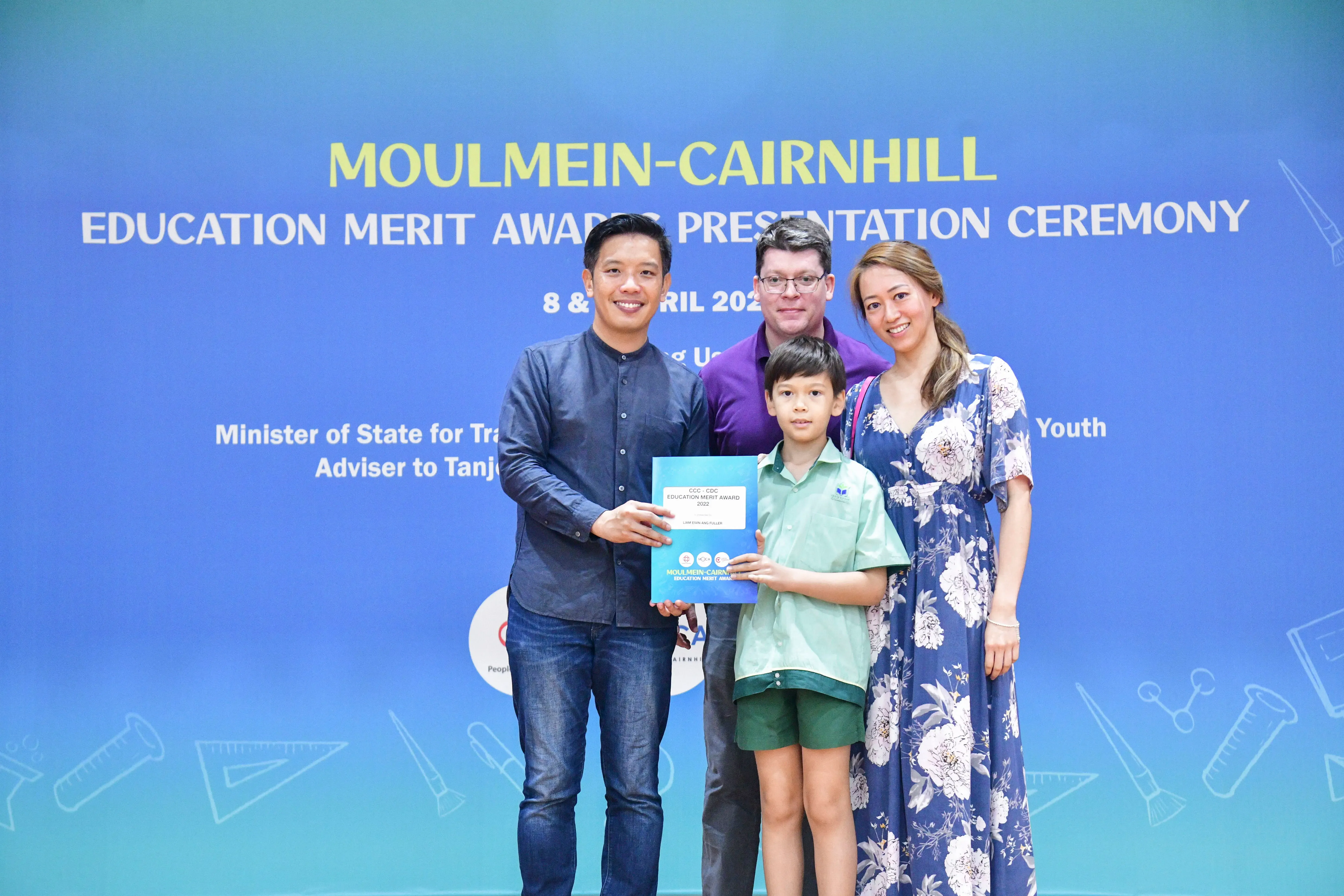 Four people pose with a certificate at the Moulmein-Cairnhill Education Merit Award Presentation Ceremony.