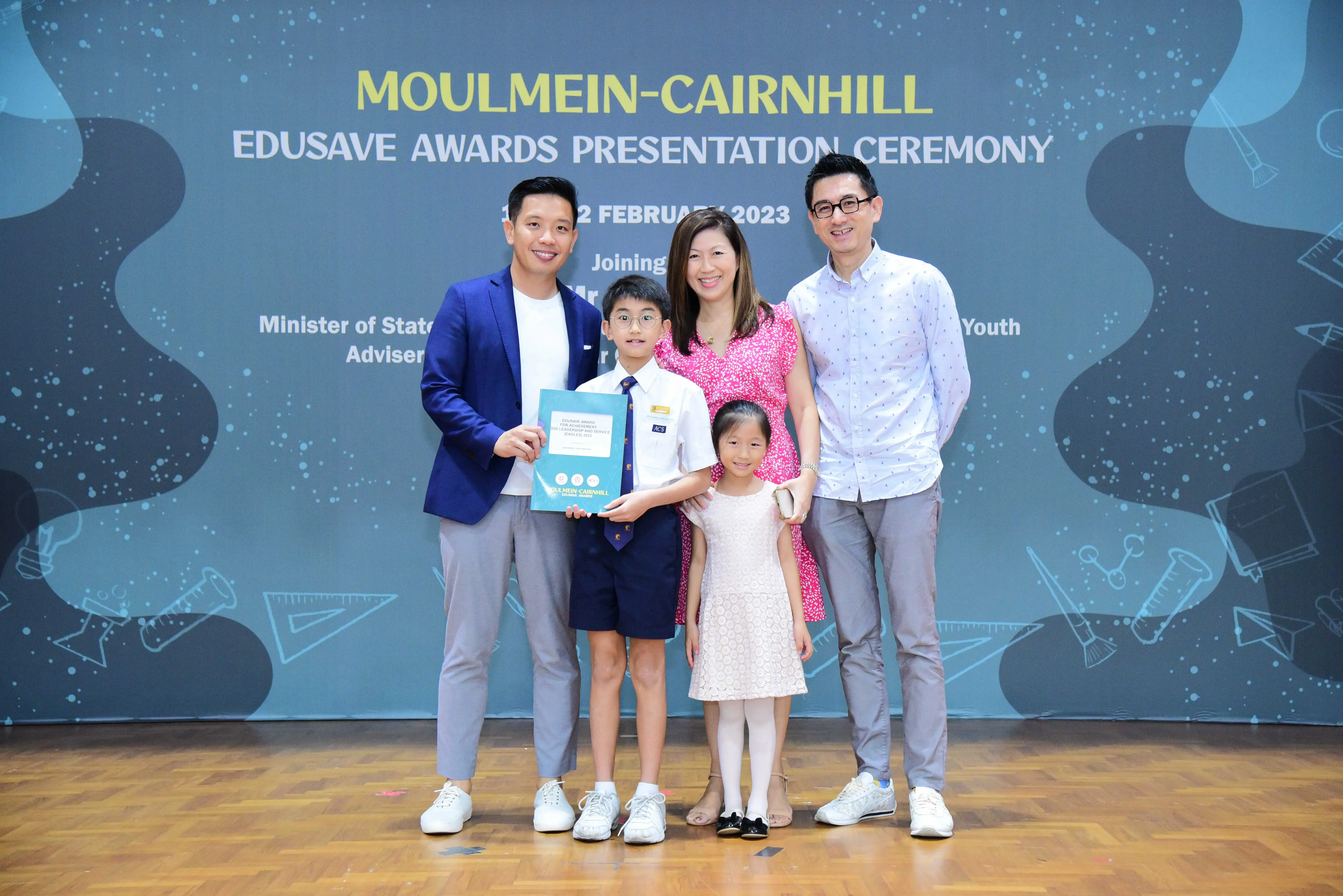 Five people pose at the Moulmein-Cairnhill Edusave Awards Presentation Ceremony in February 2023, holding a certificate.