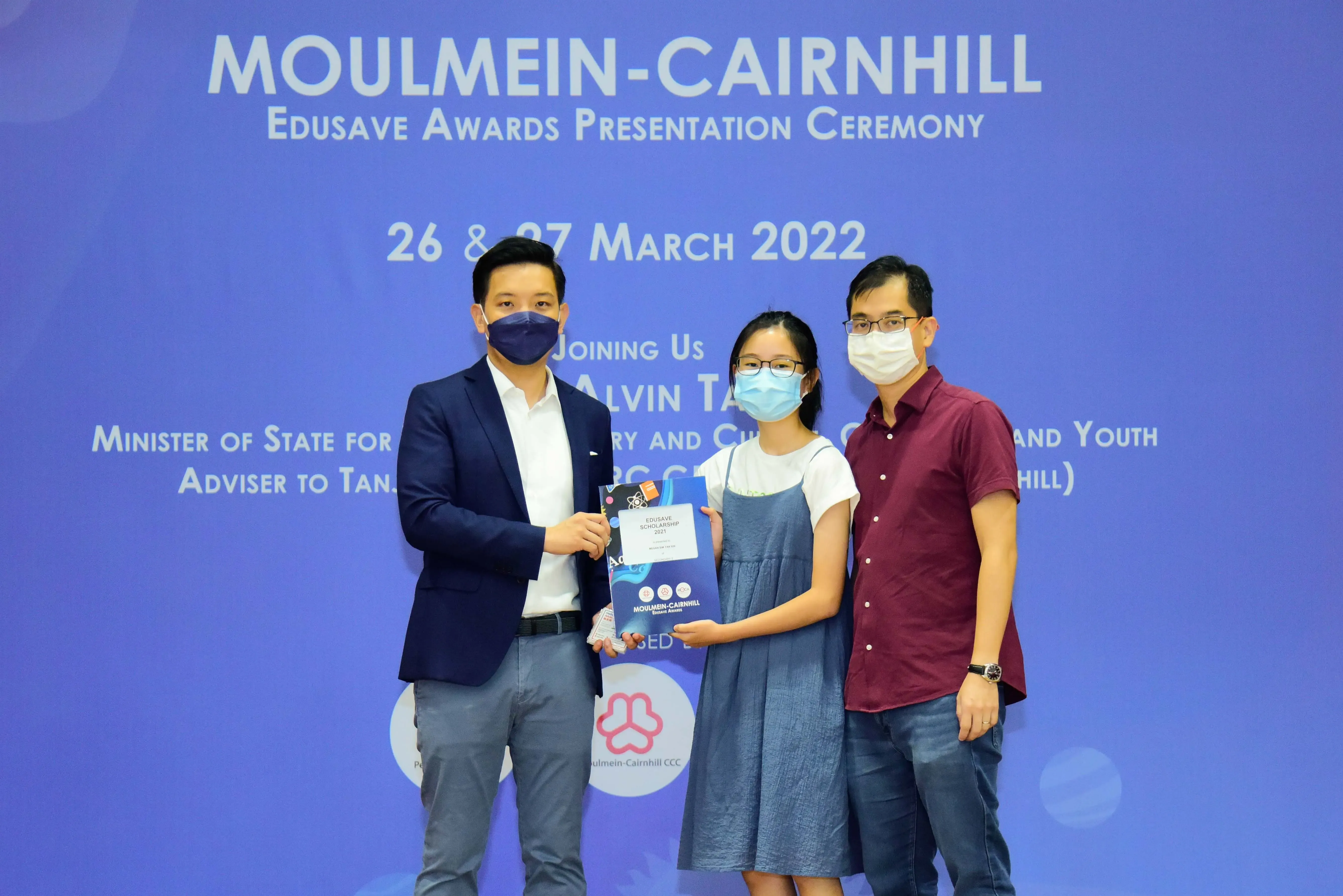 Three masked people pose at the Moulmein-Cairnhill Edusave Awards Ceremony on 26-27 March 2022.