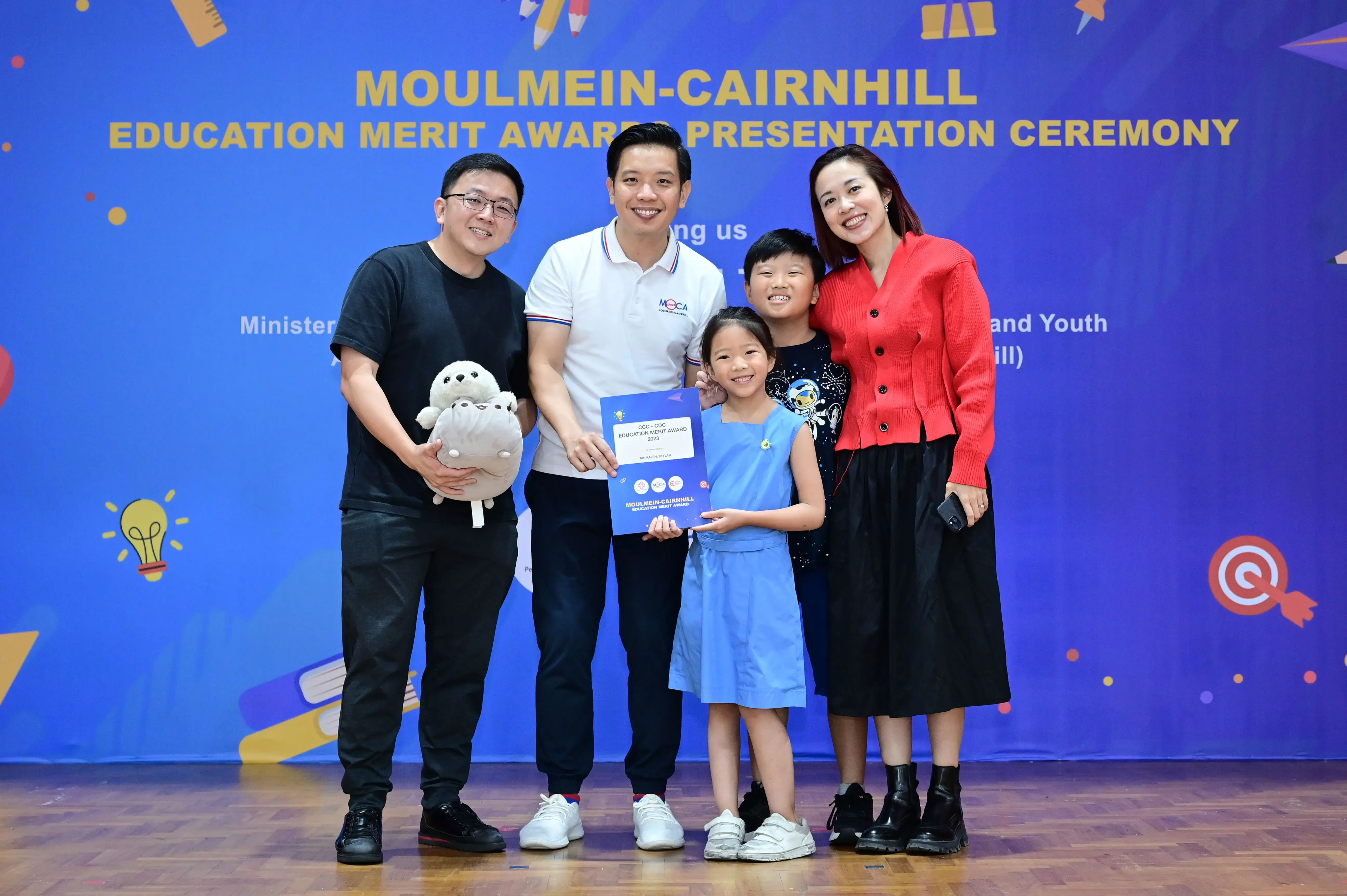 Five people pose with an award certificate at the Moulmein-Cairnhill Education Merit Awards Presentation Ceremony.