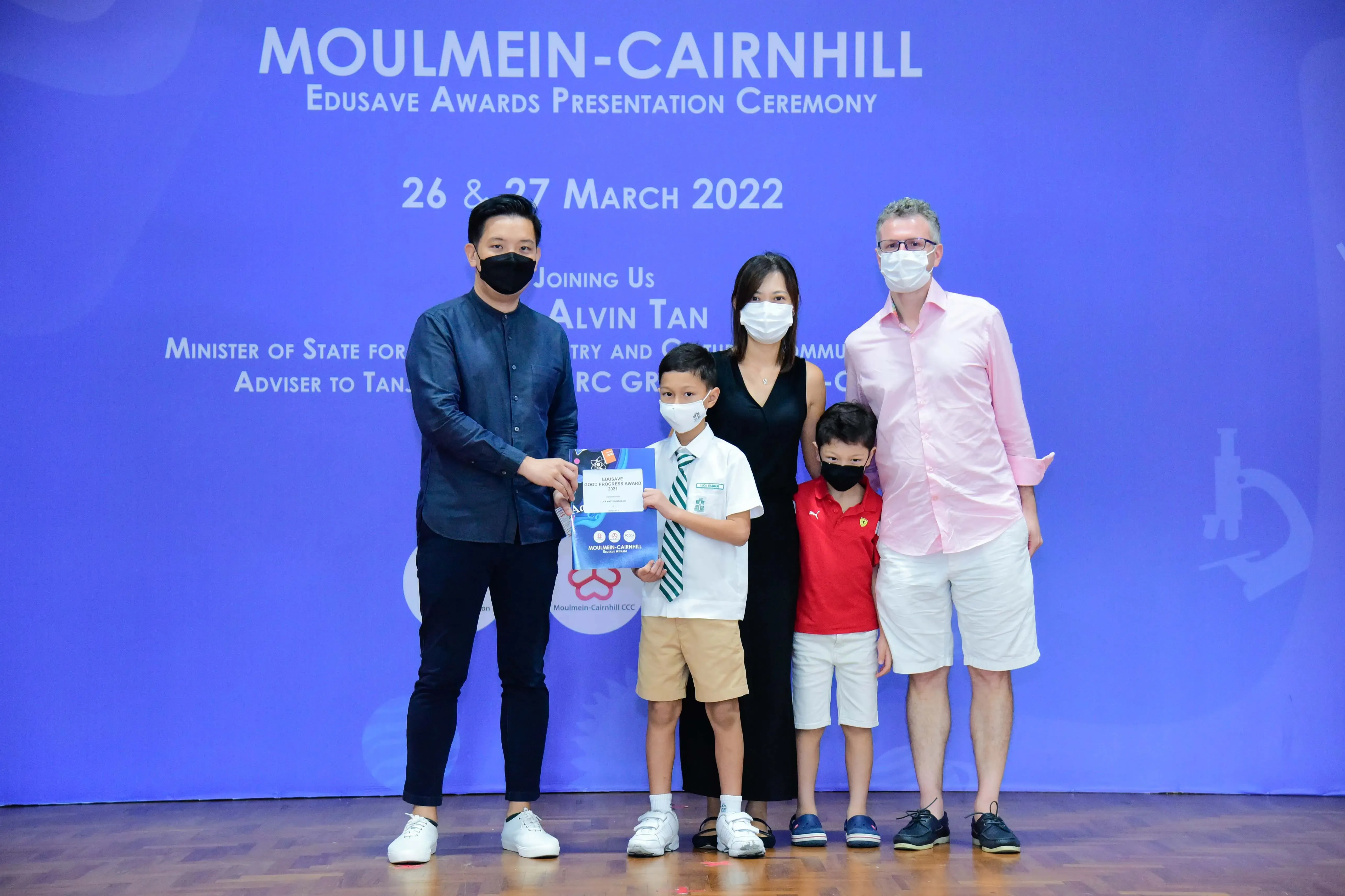 Five masked people pose at the Moulmein-Cairnhill Edusave Awards Ceremony on 26-27 March 2022.
