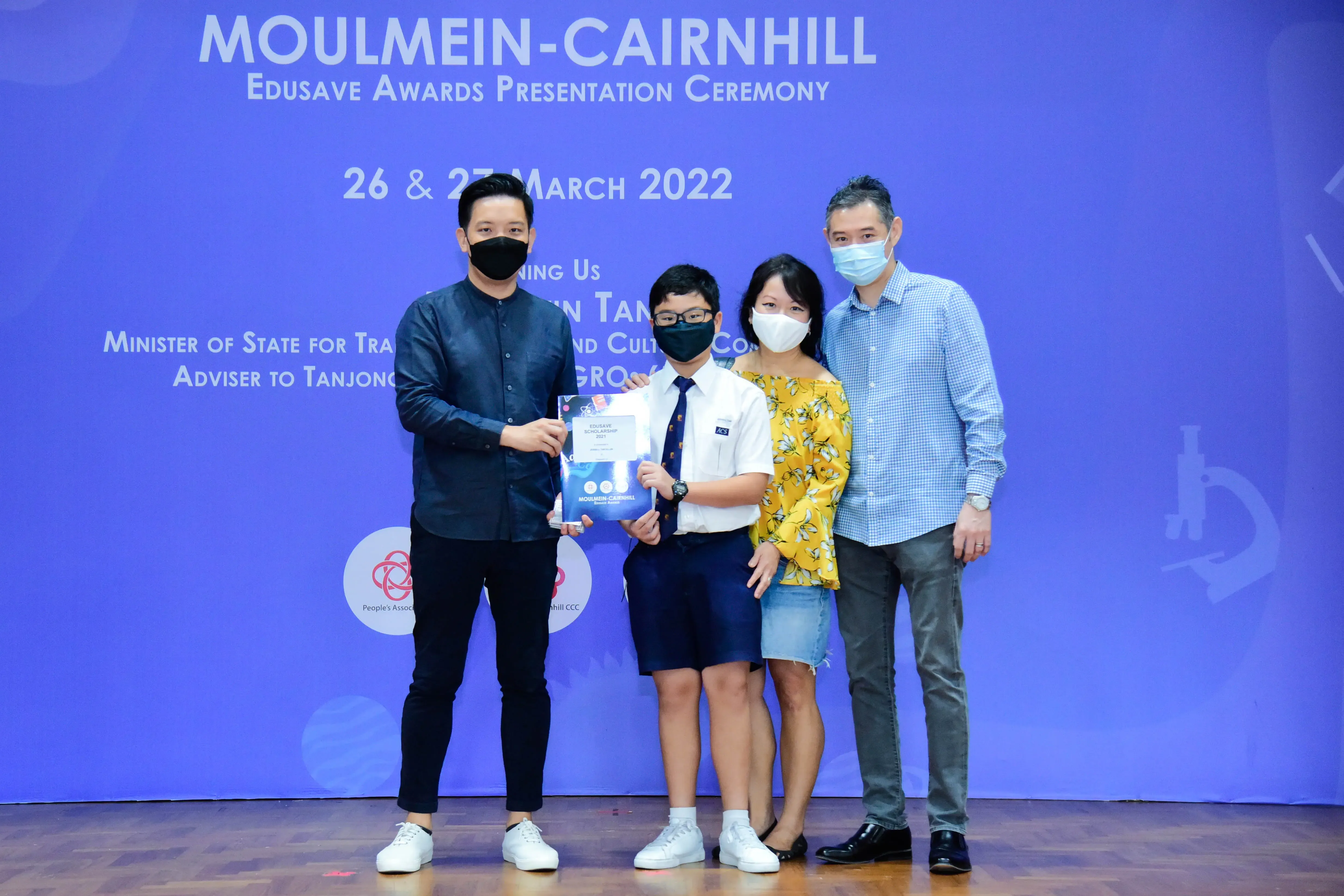 Four masked people pose at the Moulmein-Cairnhill Edusave Awards Presentation Ceremony on 26-27 March 2022.