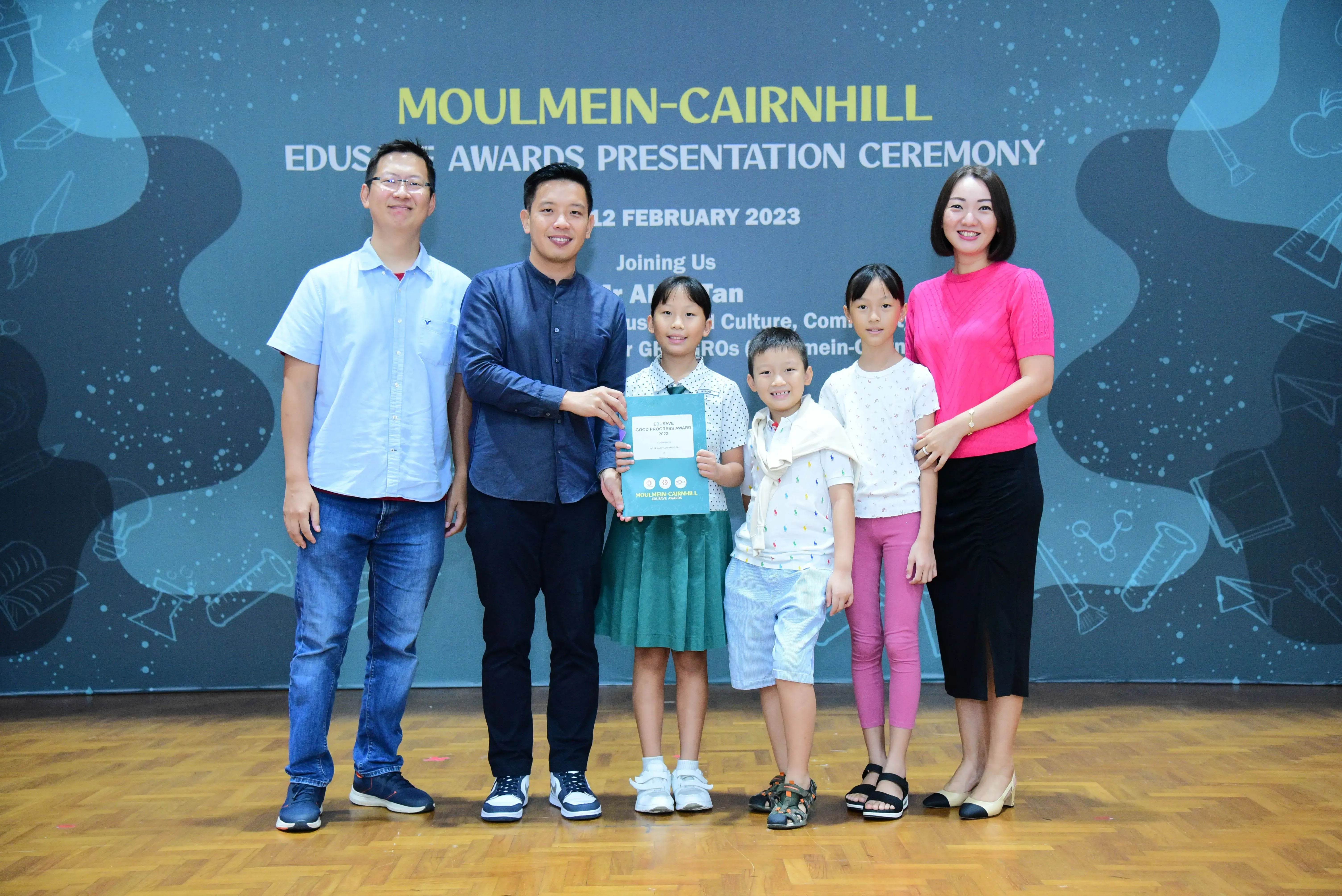 Two adults and three children pose at the Moulmein-Cairnhill Edusave Awards Presentation Ceremony on 12 February 2023.