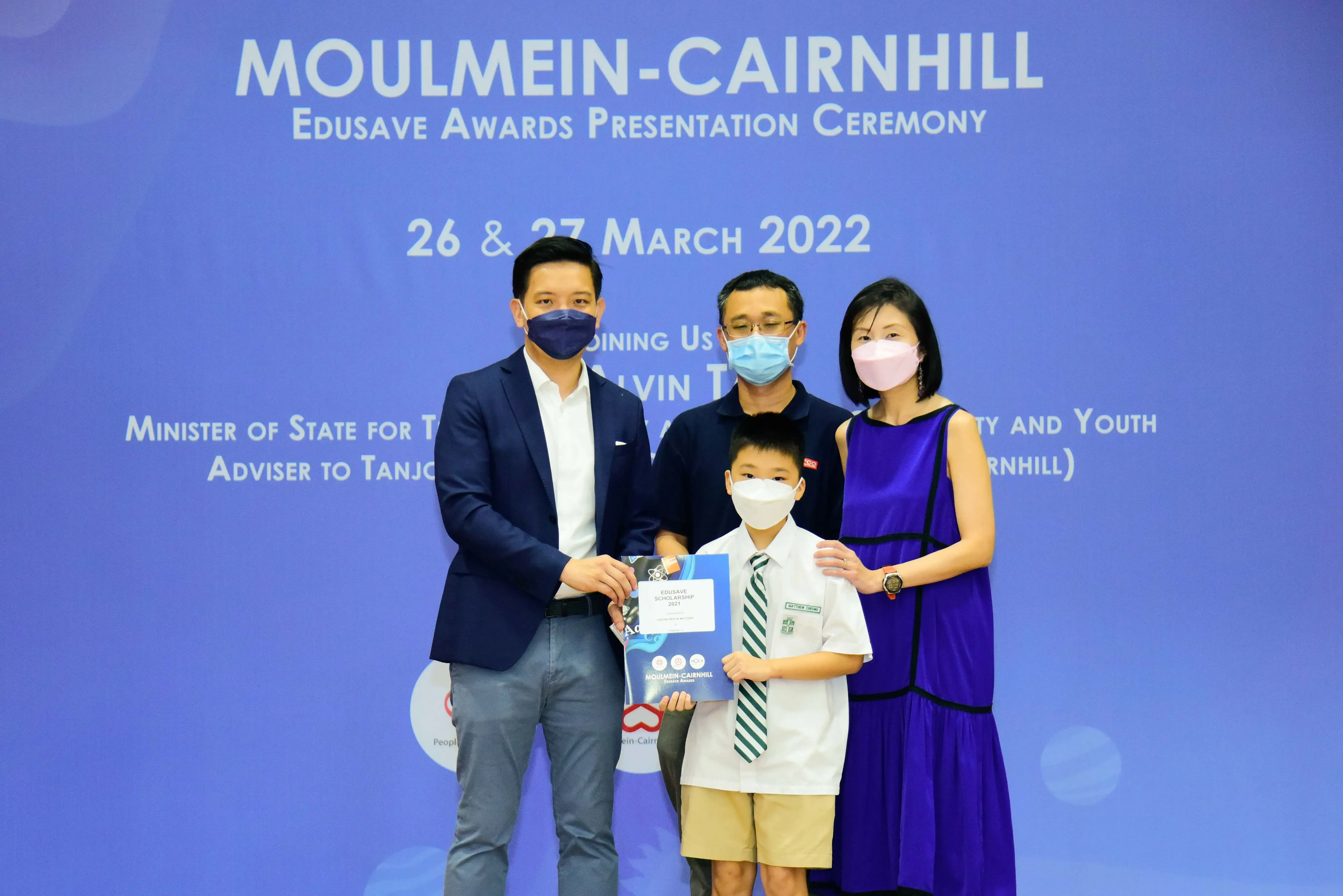 Four masked people pose at the Moulmein-Cairnhill Edusave Awards Presentation Ceremony on 26-27 March 2022.