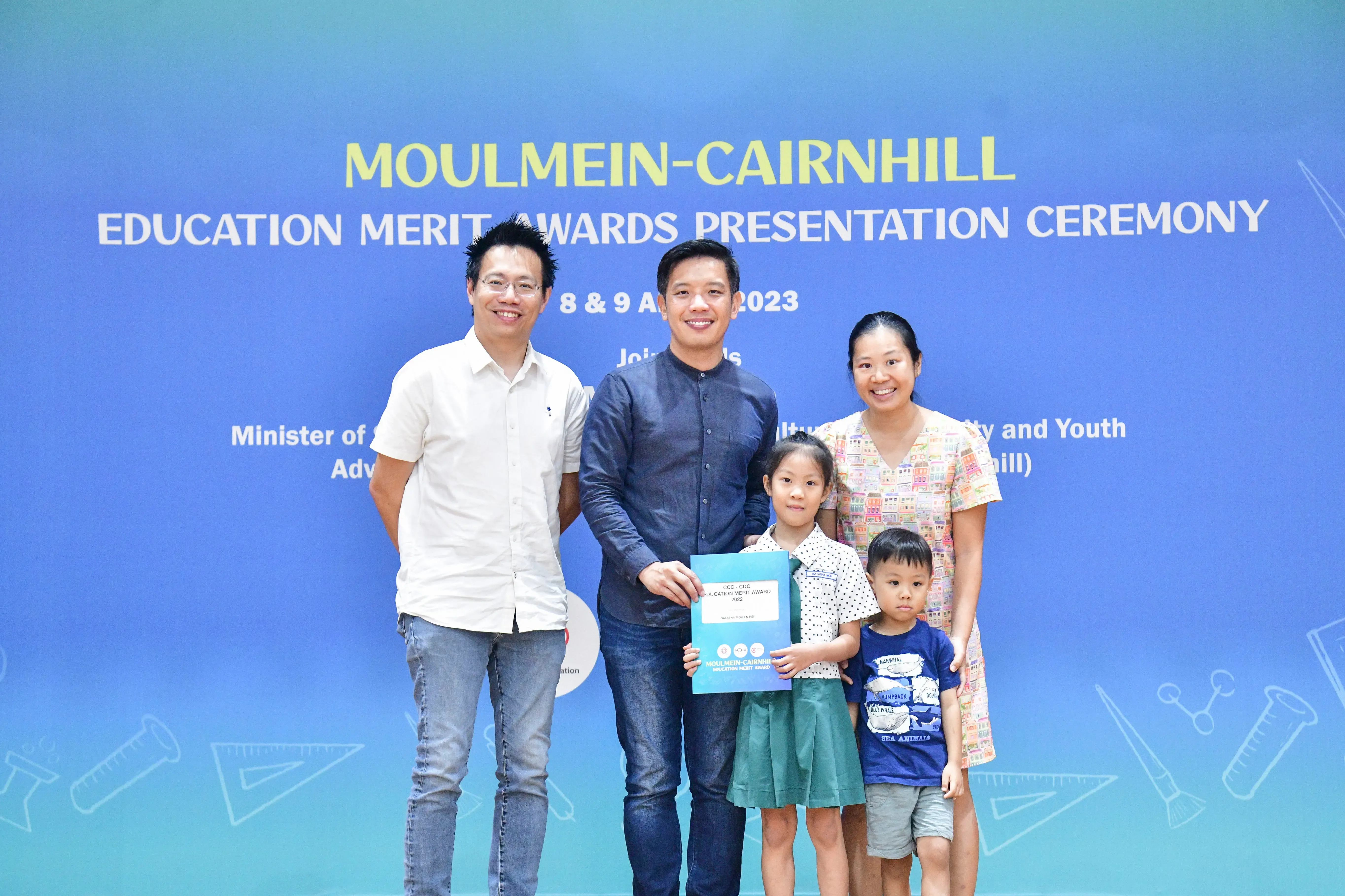Three adults and two children pose at the Moulmein-Cairnhill Education Merit Awards Presentation Ceremony 2023.
