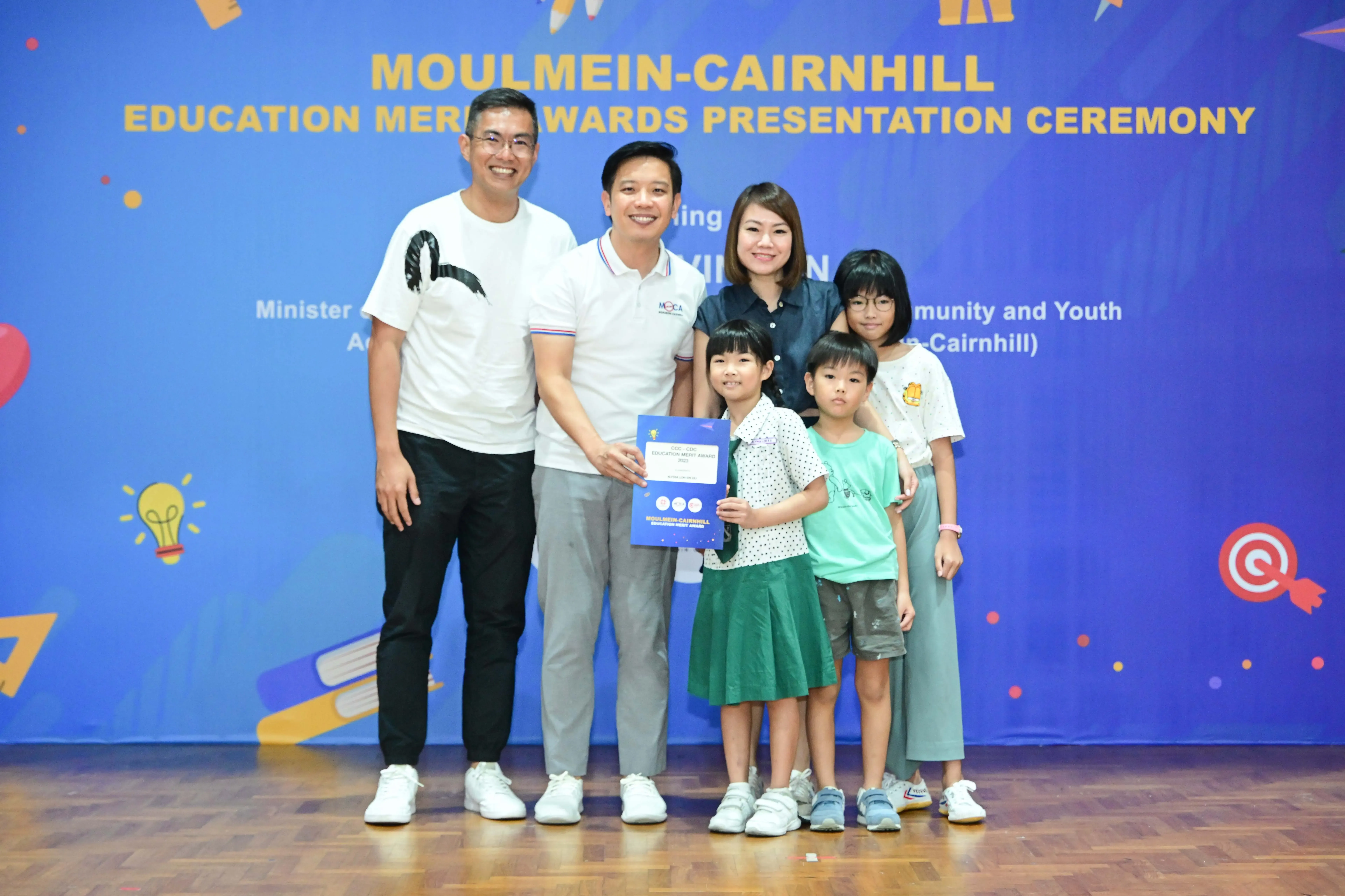 Six people pose with a certificate at the Moulmein-Cairnhill Education Merit Awards Presentation Ceremony.