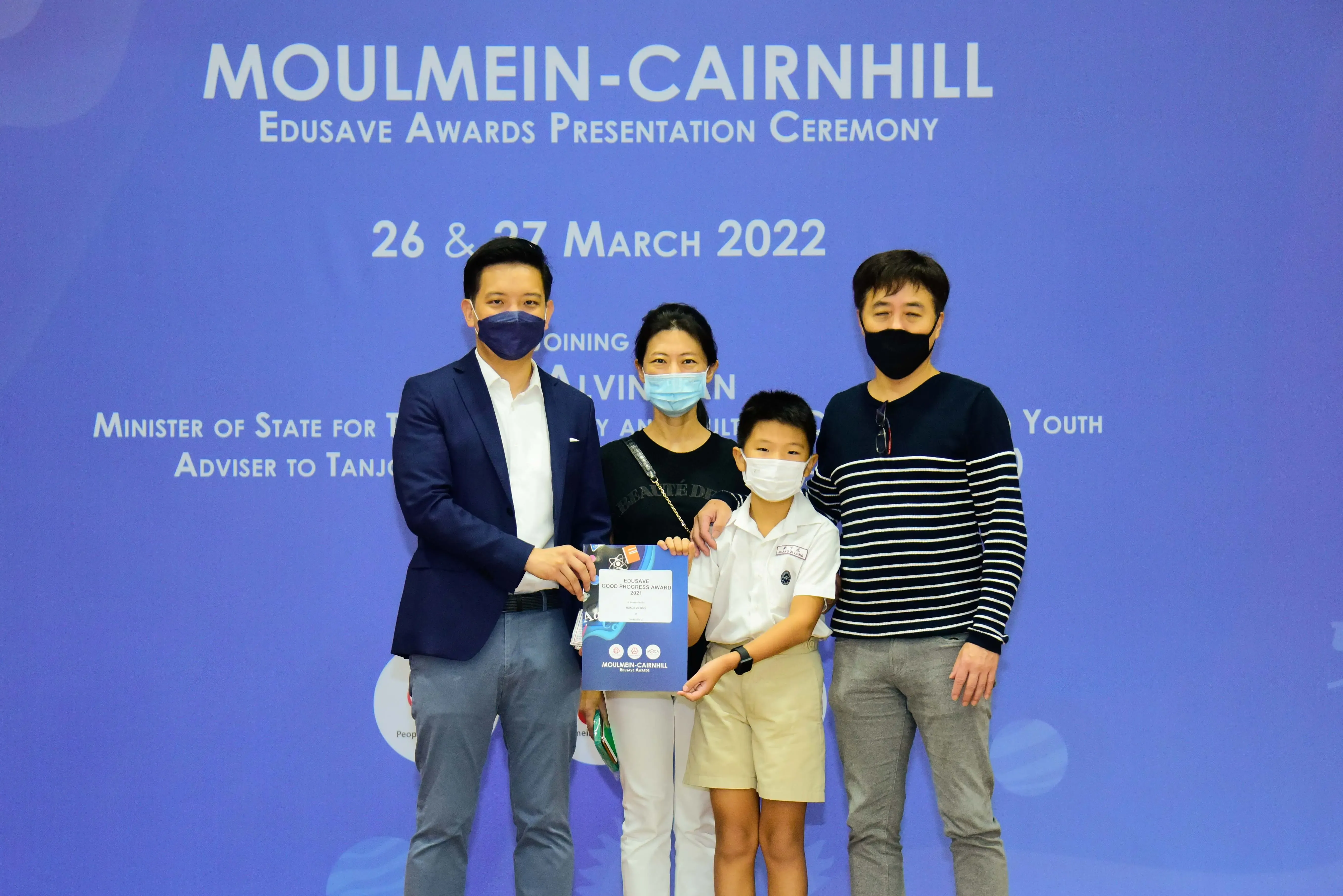 Four masked people pose at the Moulmein-Cairnhill Edusave Awards Presentation Ceremony on 26-27 March 2022.